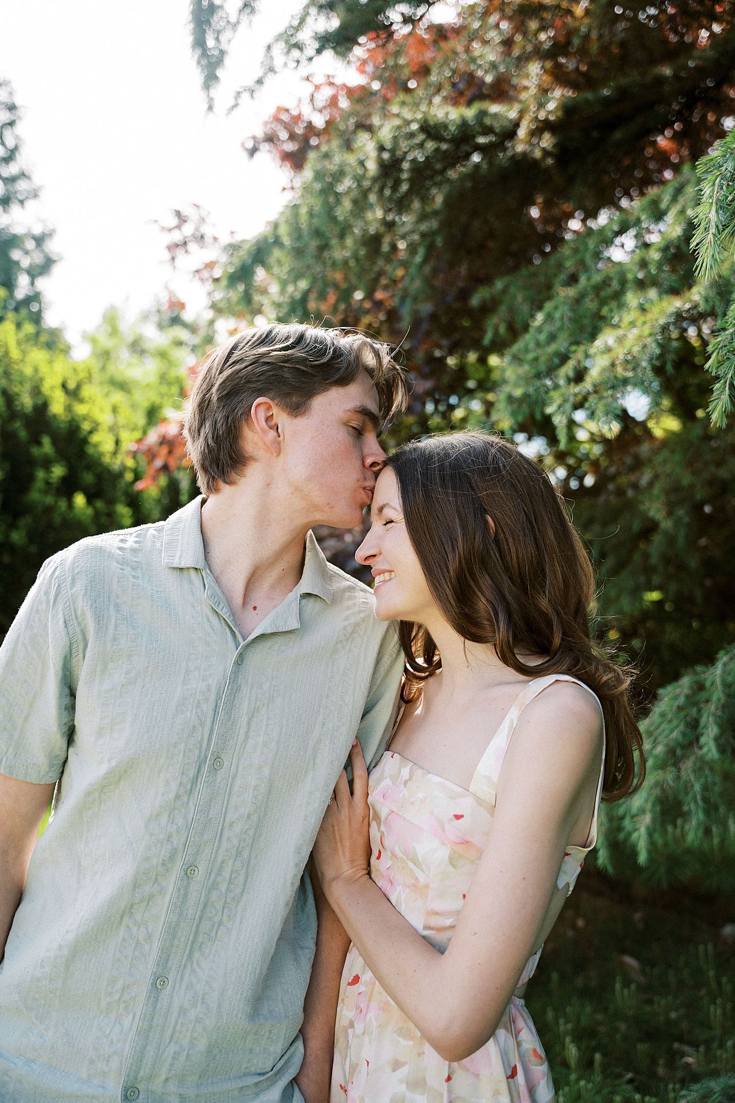 man kisses brunette on her forehead outside by Camille Meers Photography 