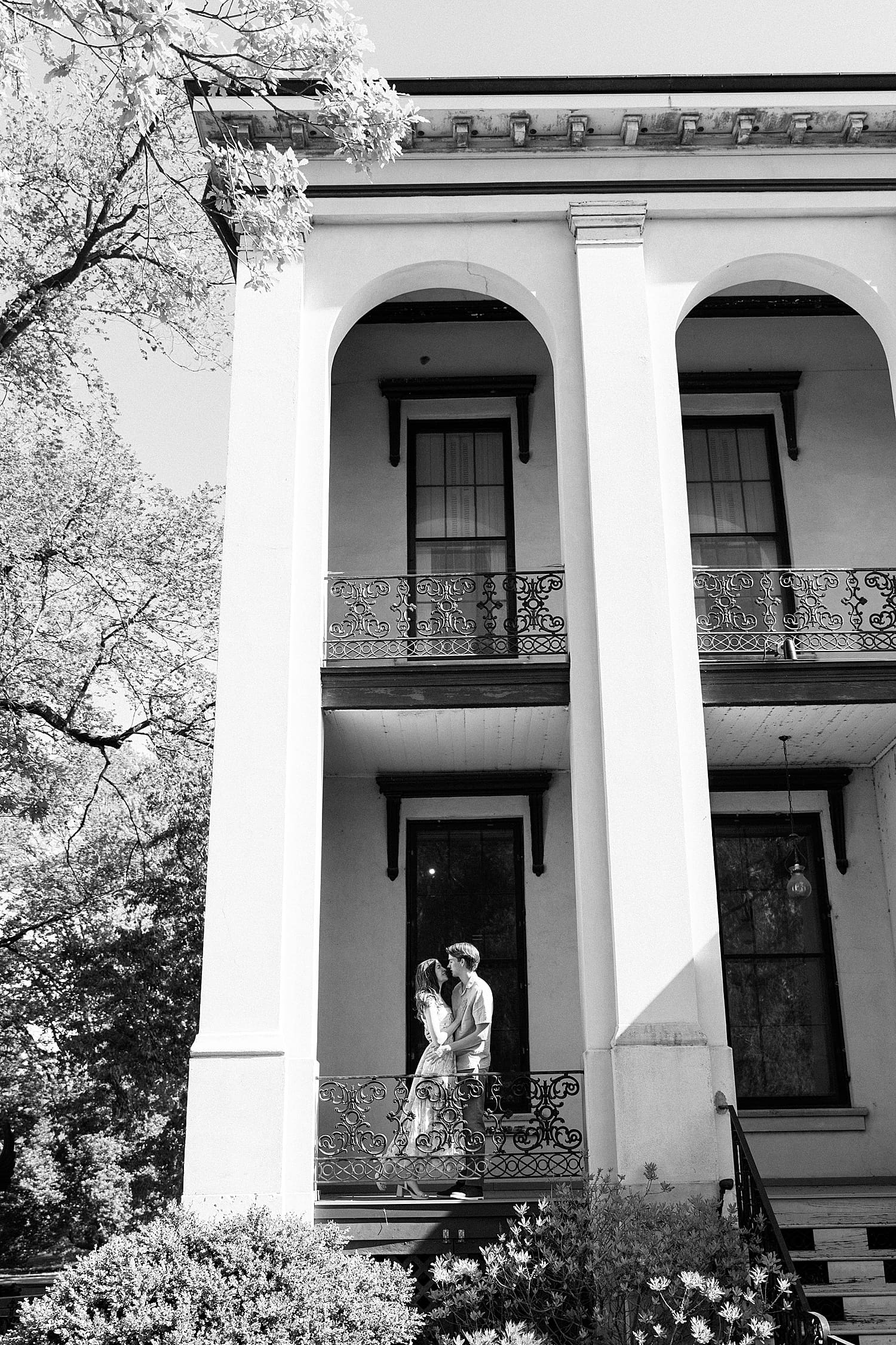 couple stand under large archway in building by St. Louis wedding Photographer