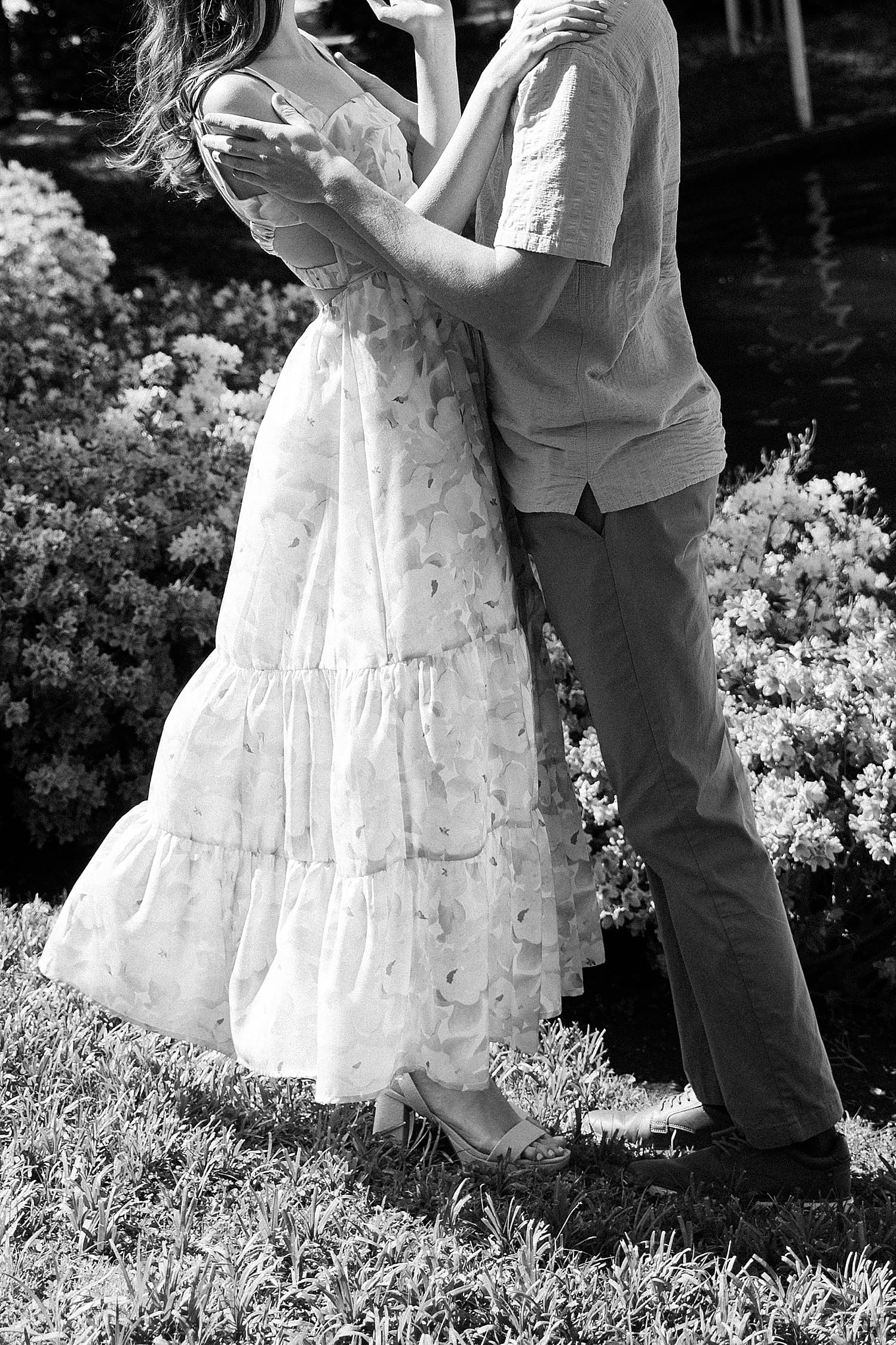 man and woman stand in garden for a hug by Camille Meers Photography 