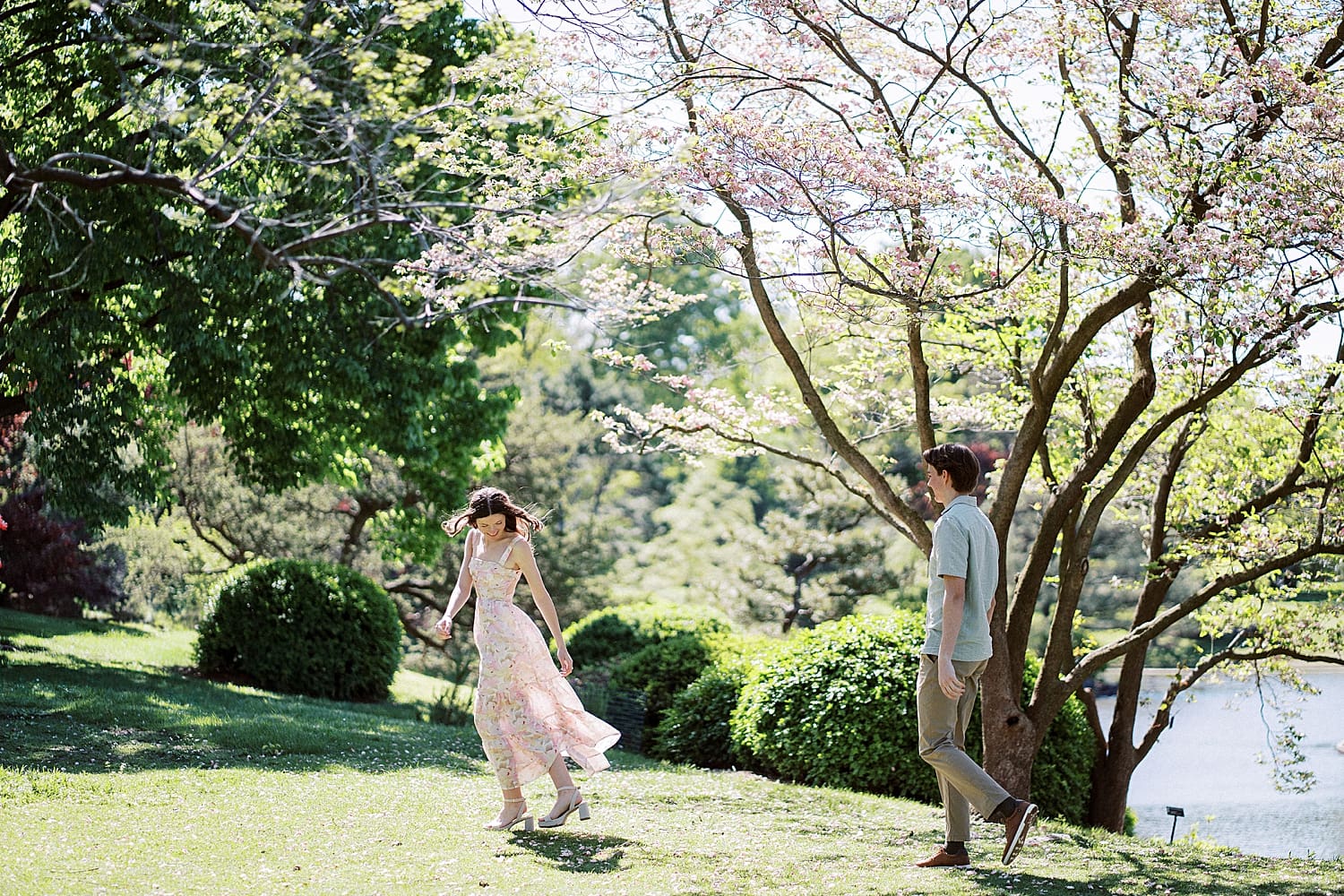 woman runs in the park while her fiance watches by St. Louis wedding Photographer