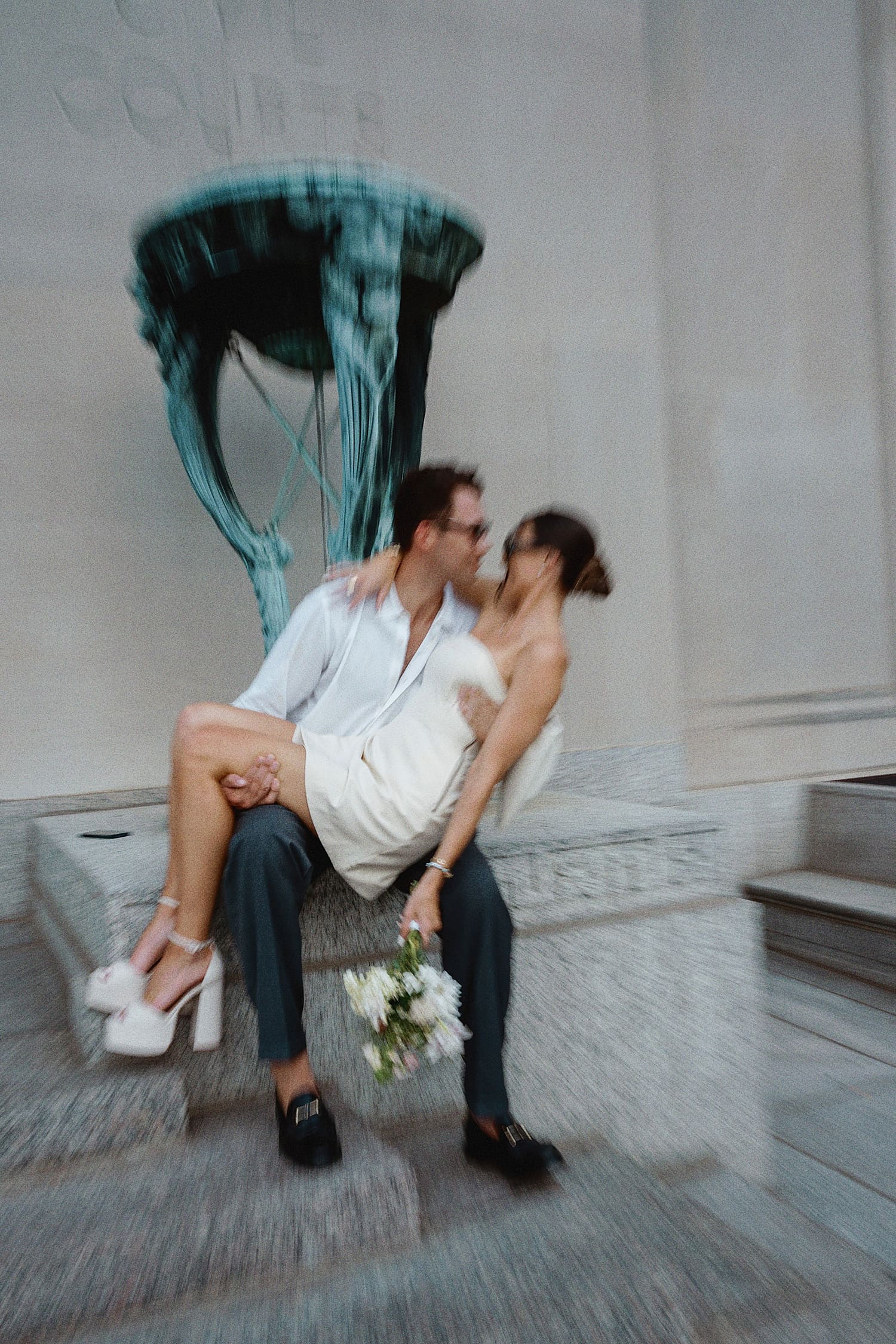 man dips woman for kiss in front of statue for editorial elopement session
