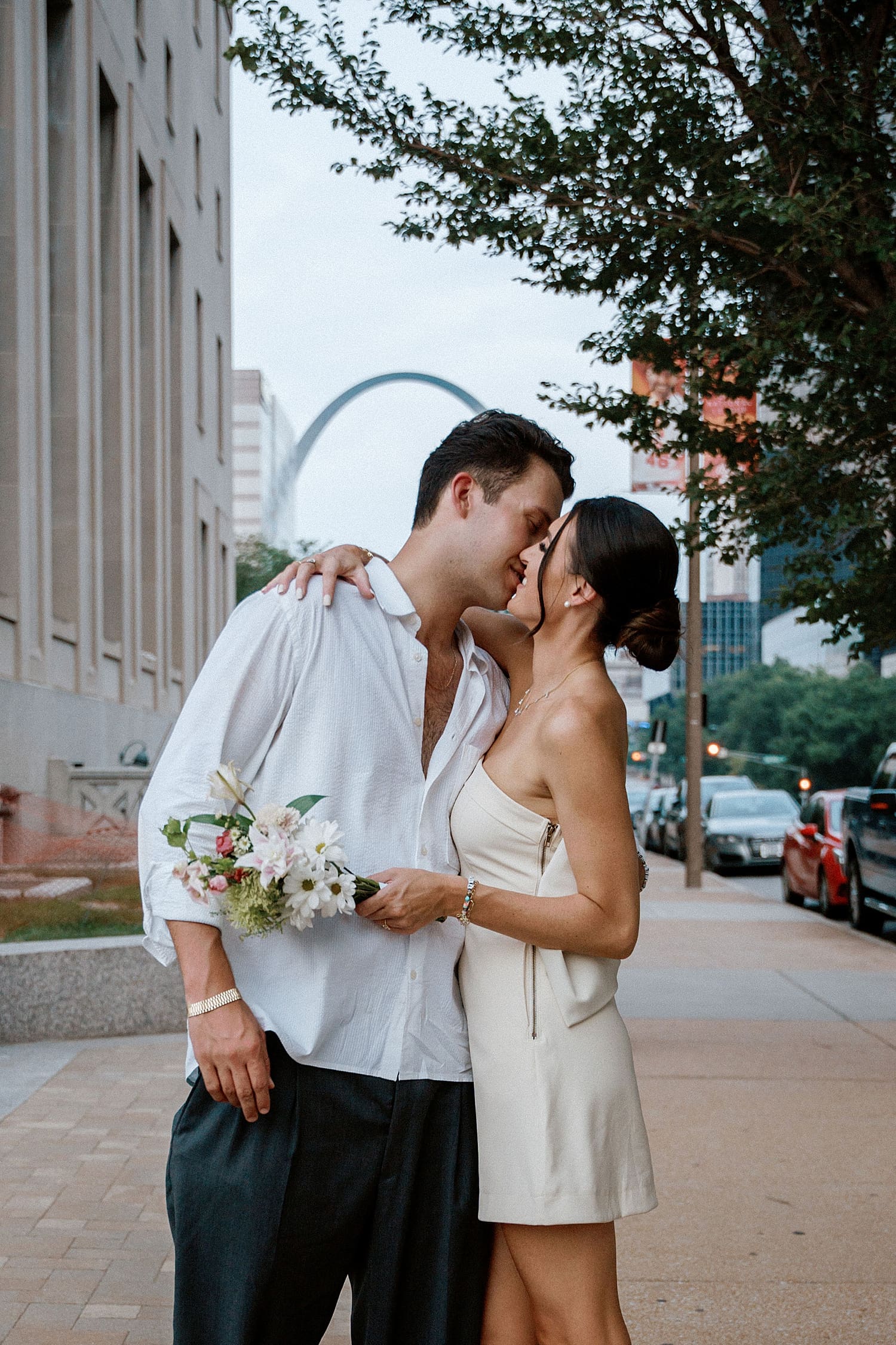 couple shares a kiss in front of Arch by Camille Meers Photography