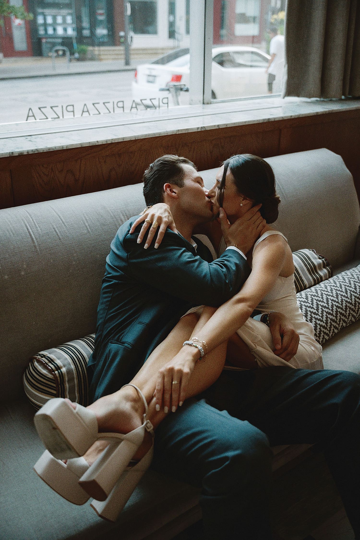 couple snuggles on the couch and share a kiss by St. Louis Wedding Photographer