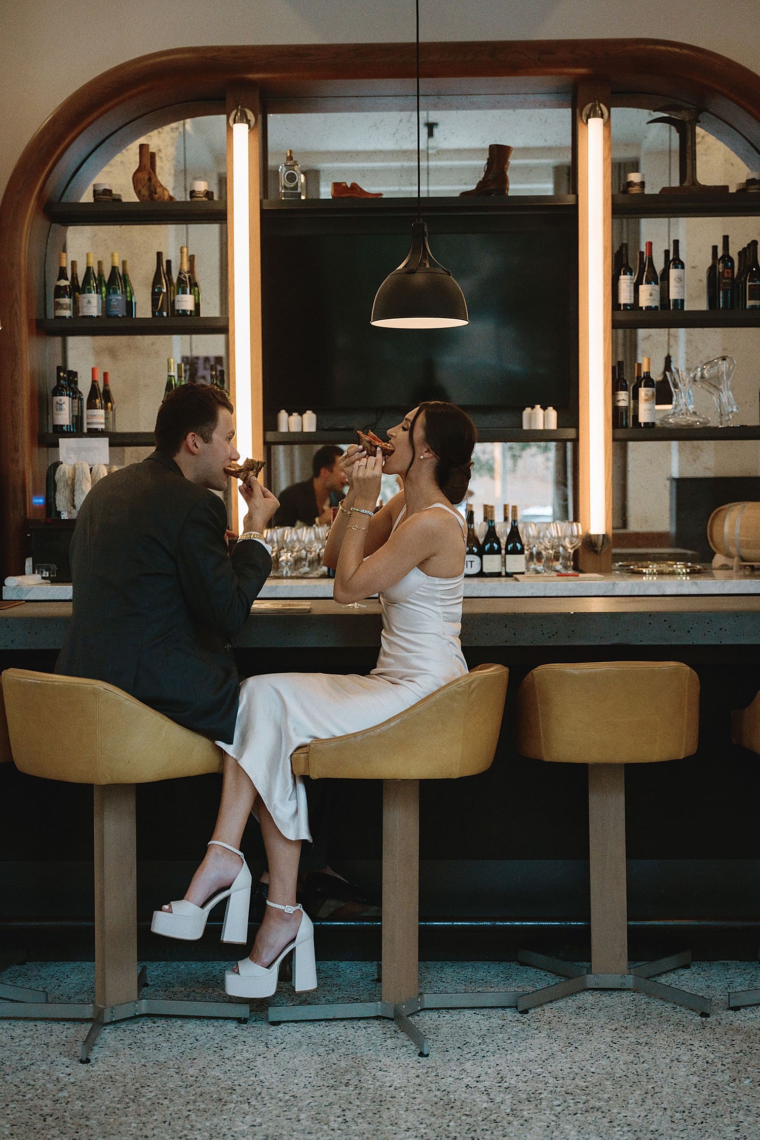 man and woman share pizza at a bar top by Camille Meers Photography