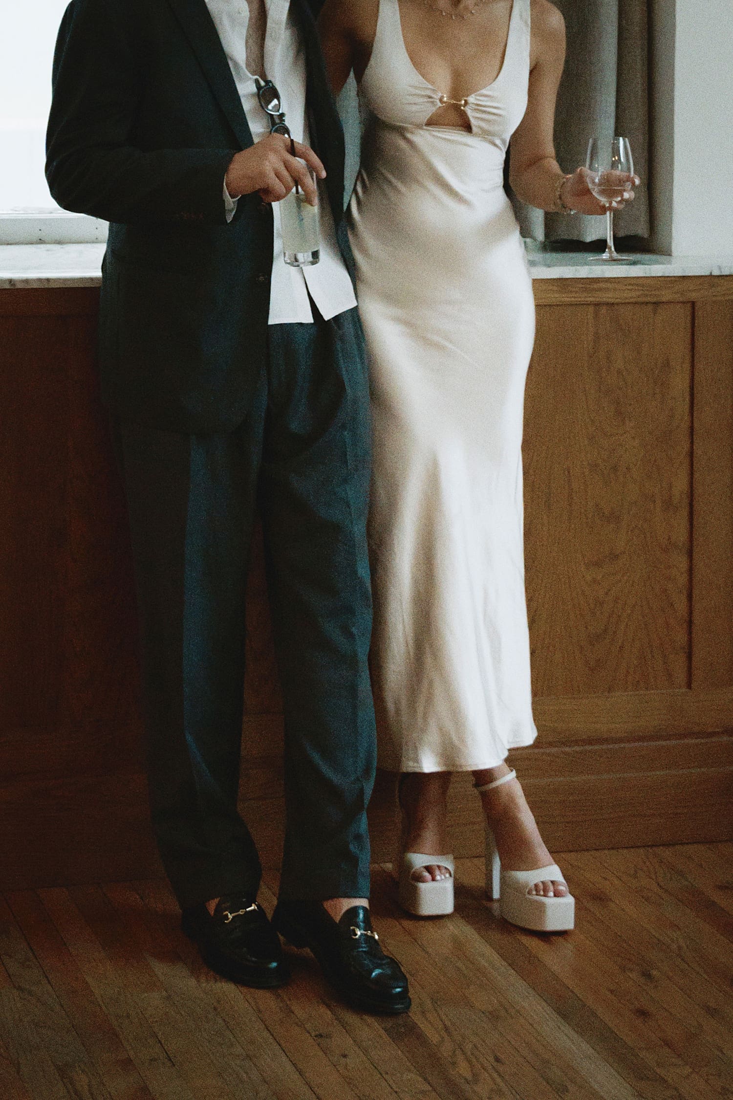 newlyweds stand with wine in hand by bar for editorial elopement session