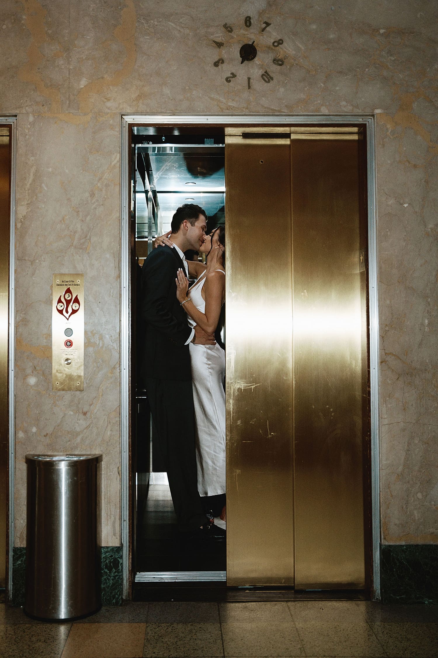 couple share a kiss as elevator doors close for editorial elopement session
