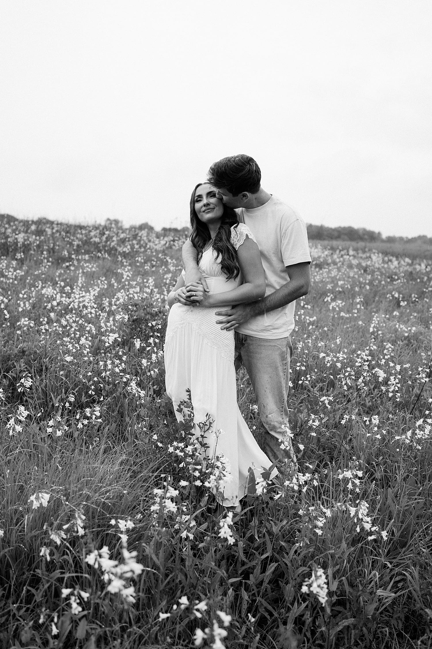 man reaches around woman to kiss her temple by St. Louis wedding photographer