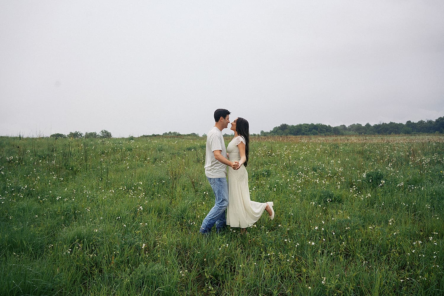 couple holds hands surrounded by flowers thinking what if it rains on your engagement session