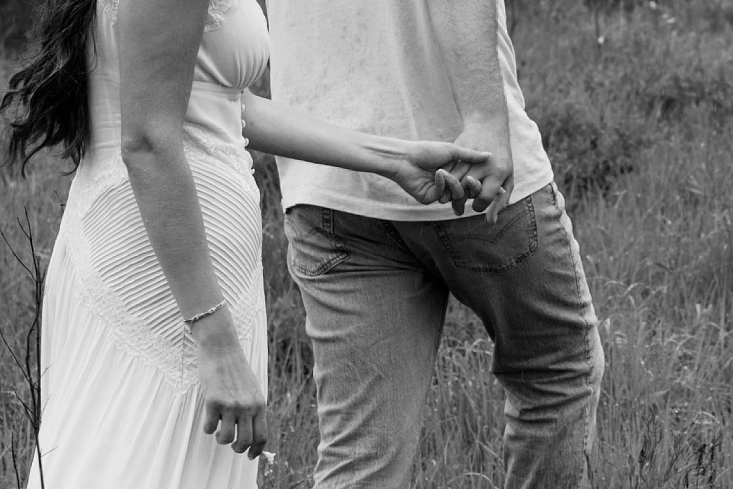 man reaches back to grasp woman's hands wondering what if it rains on your engagement session