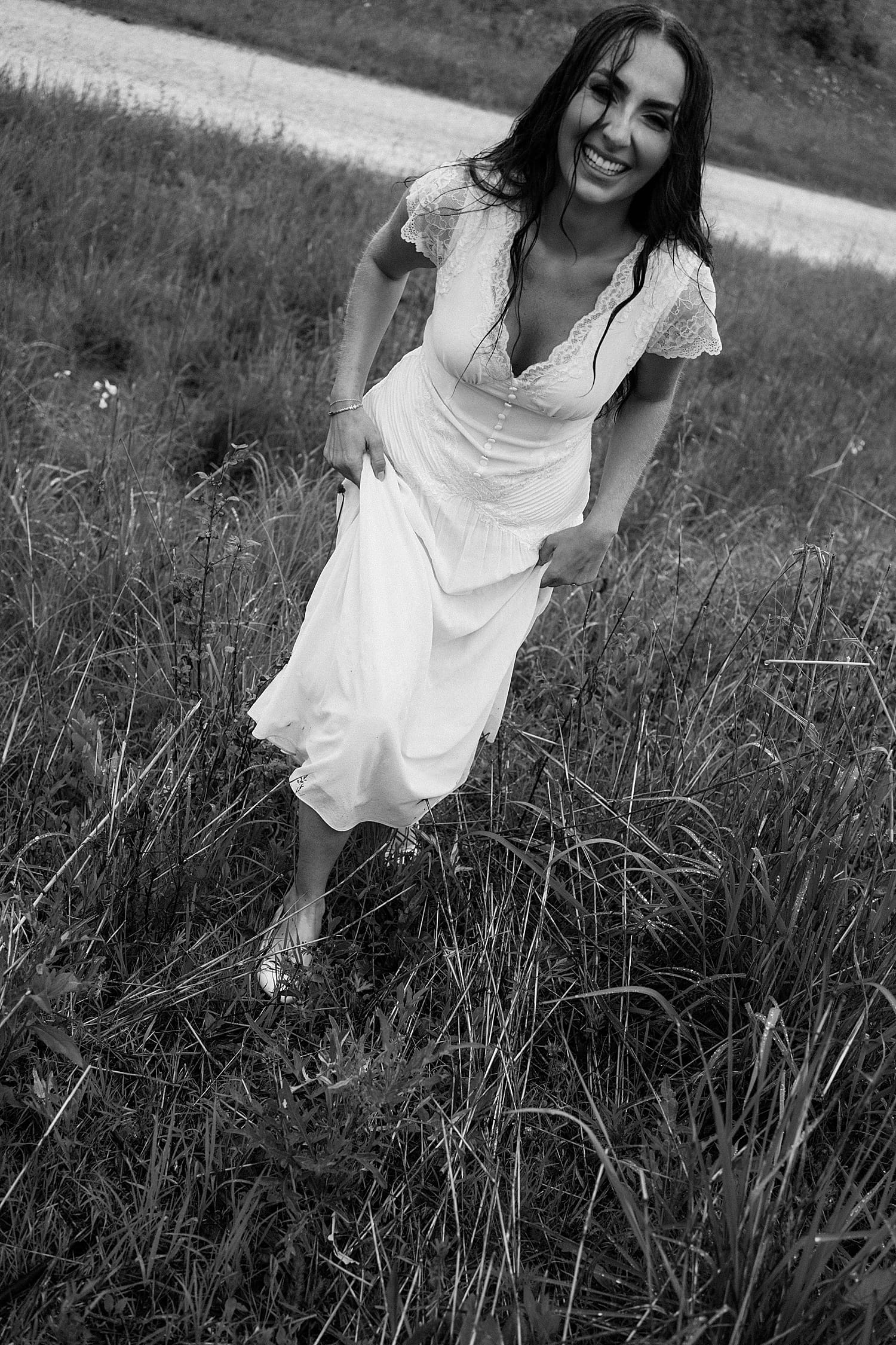 bride in white lace dress giggles with wet hair wondering what if it rains on your engagement session