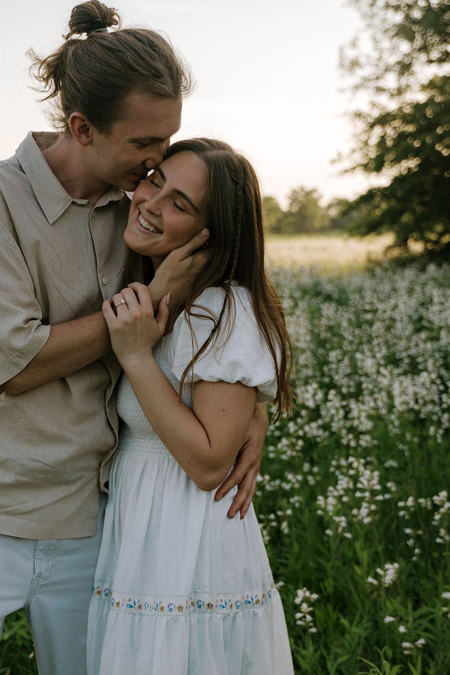 man kisses his fiance after learning the best time for Spring engagement photos