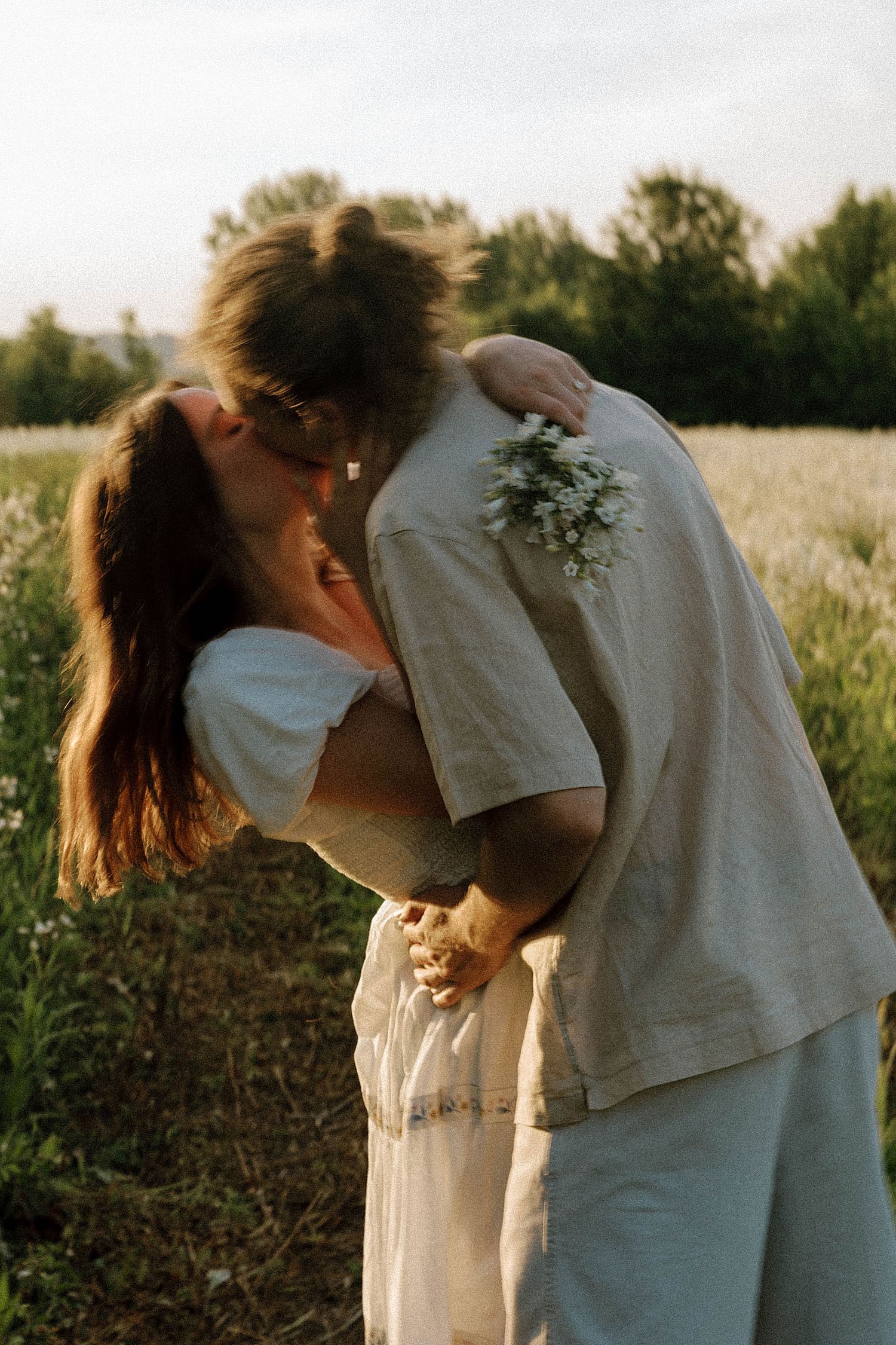 couple dip and sway in a kiss learning the best time for Spring engagement photos