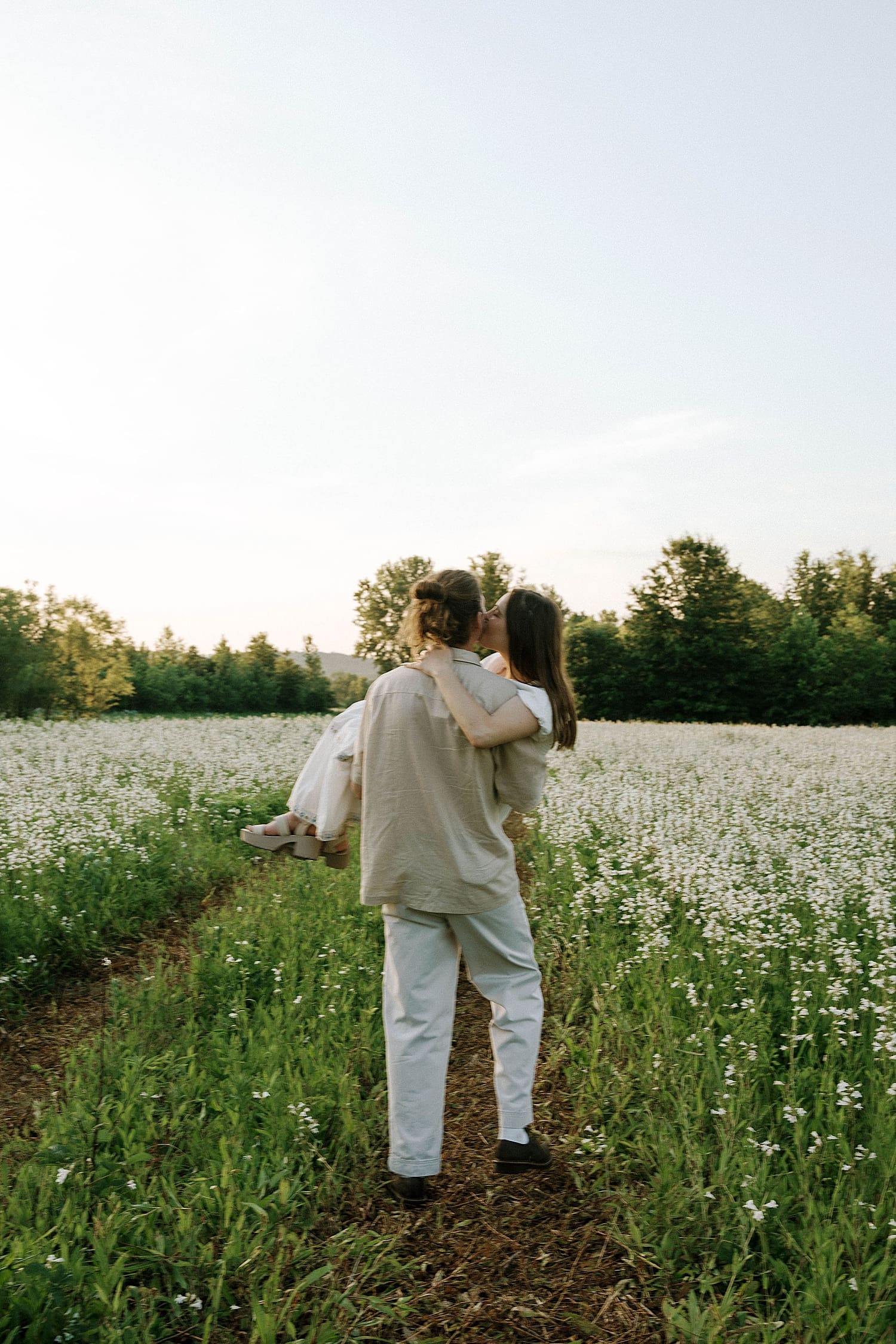 male walks through field holding his woman by St. Louis wedding photographer 