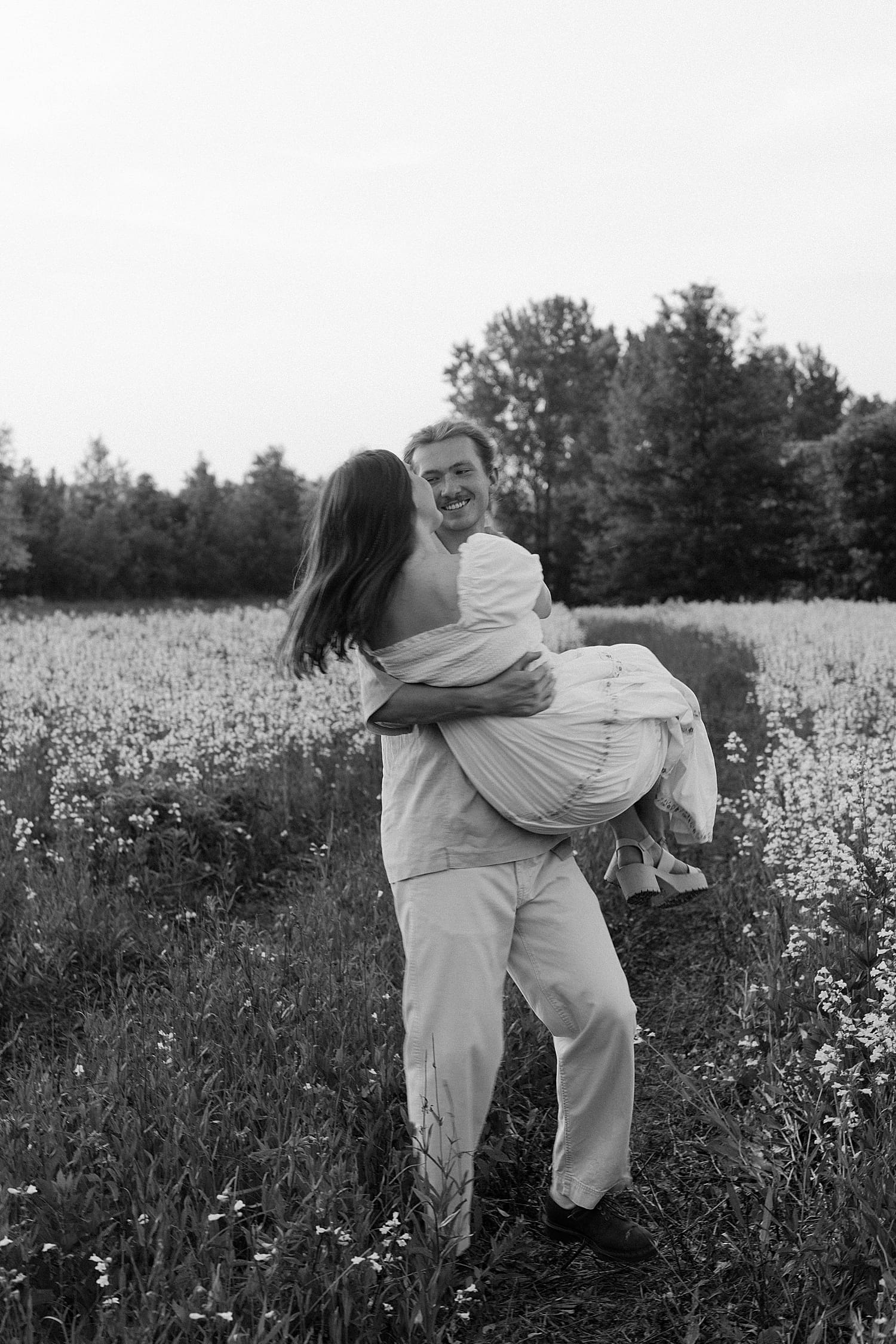 couple spin together in wildflowers by Camille Meers Photography