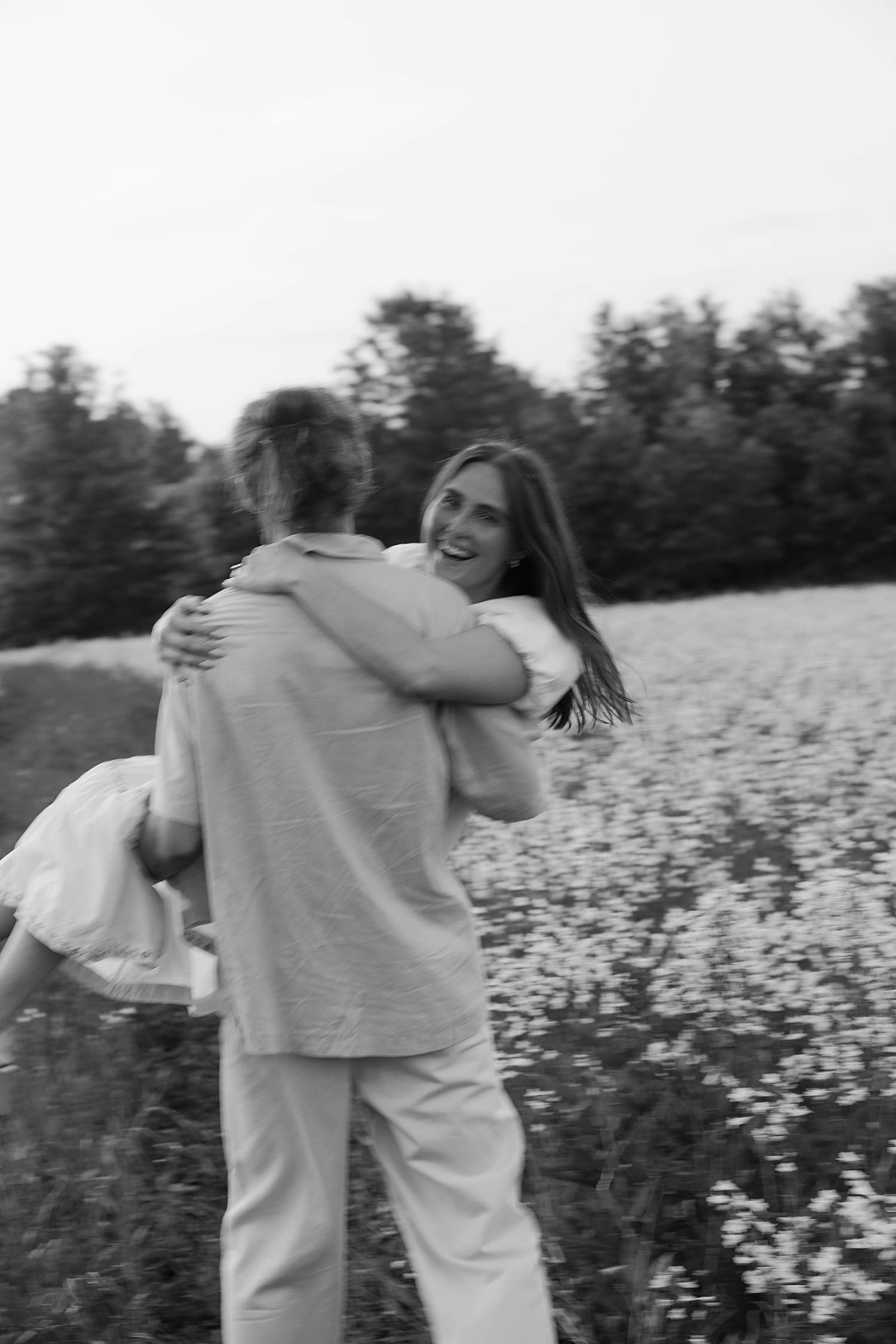 fiance twirls his girl in field of flowers by St. Louis wedding photographer 