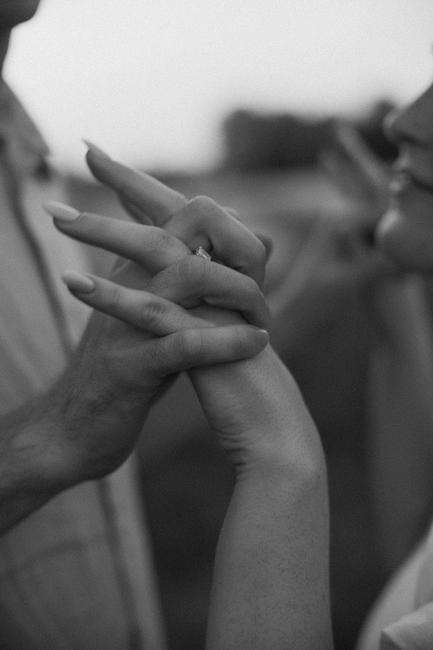 couple clasp hands in setting sun light by St. Louis wedding photographer 