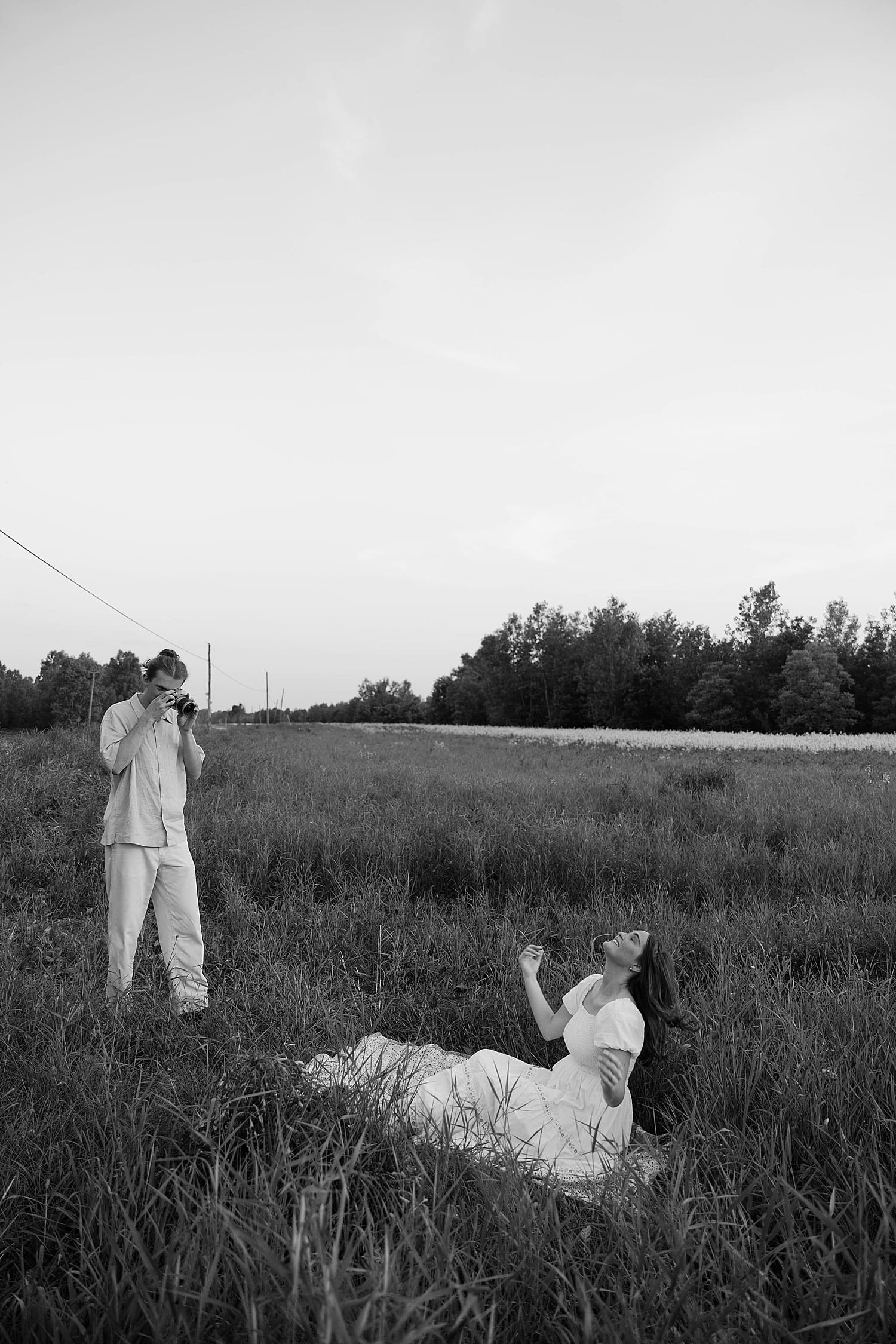 woman is photographed in field by her husband by St. Louis wedding photographer 