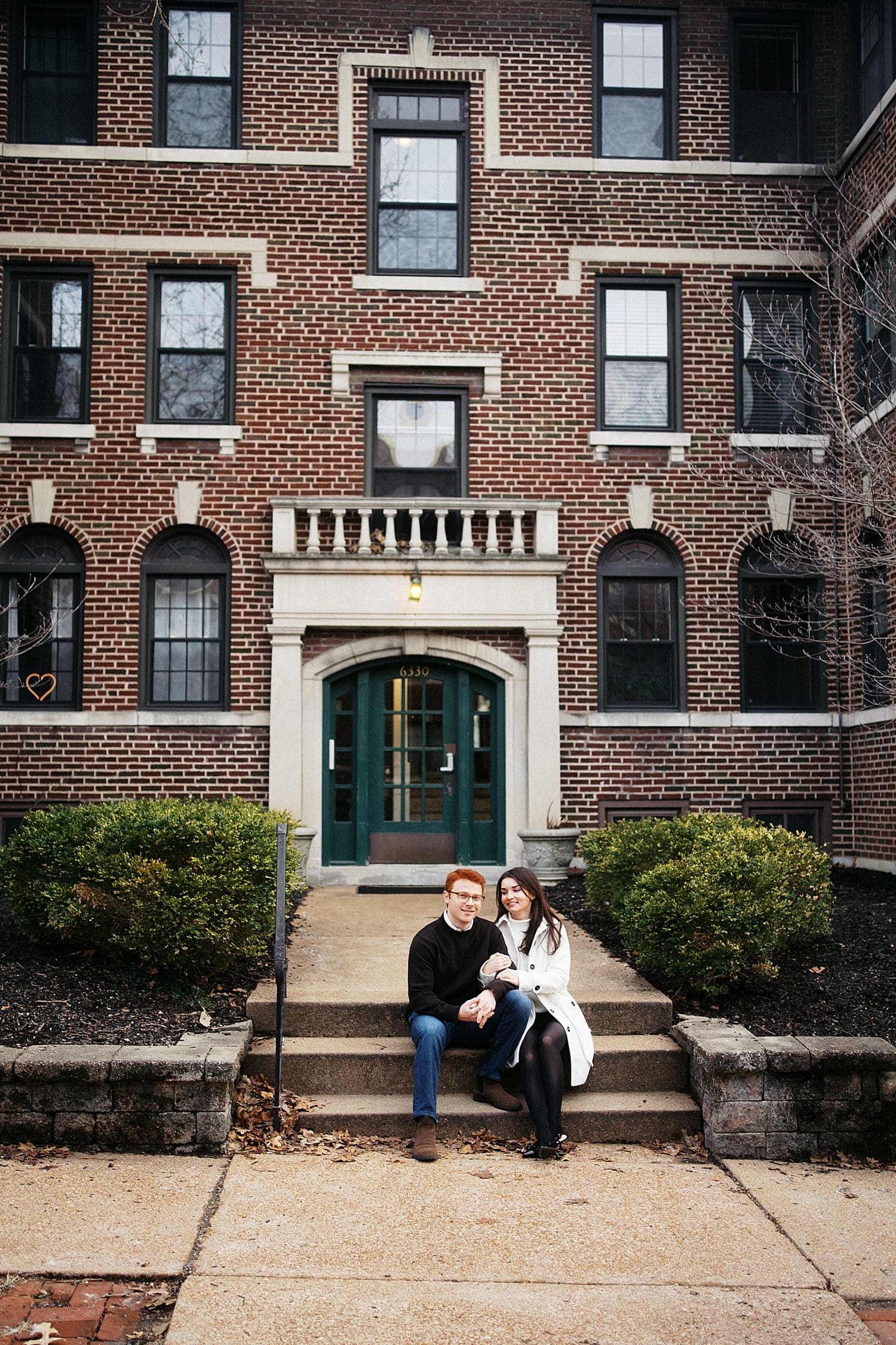 redhead man sits with his partner on steps by Camille Meers Photography