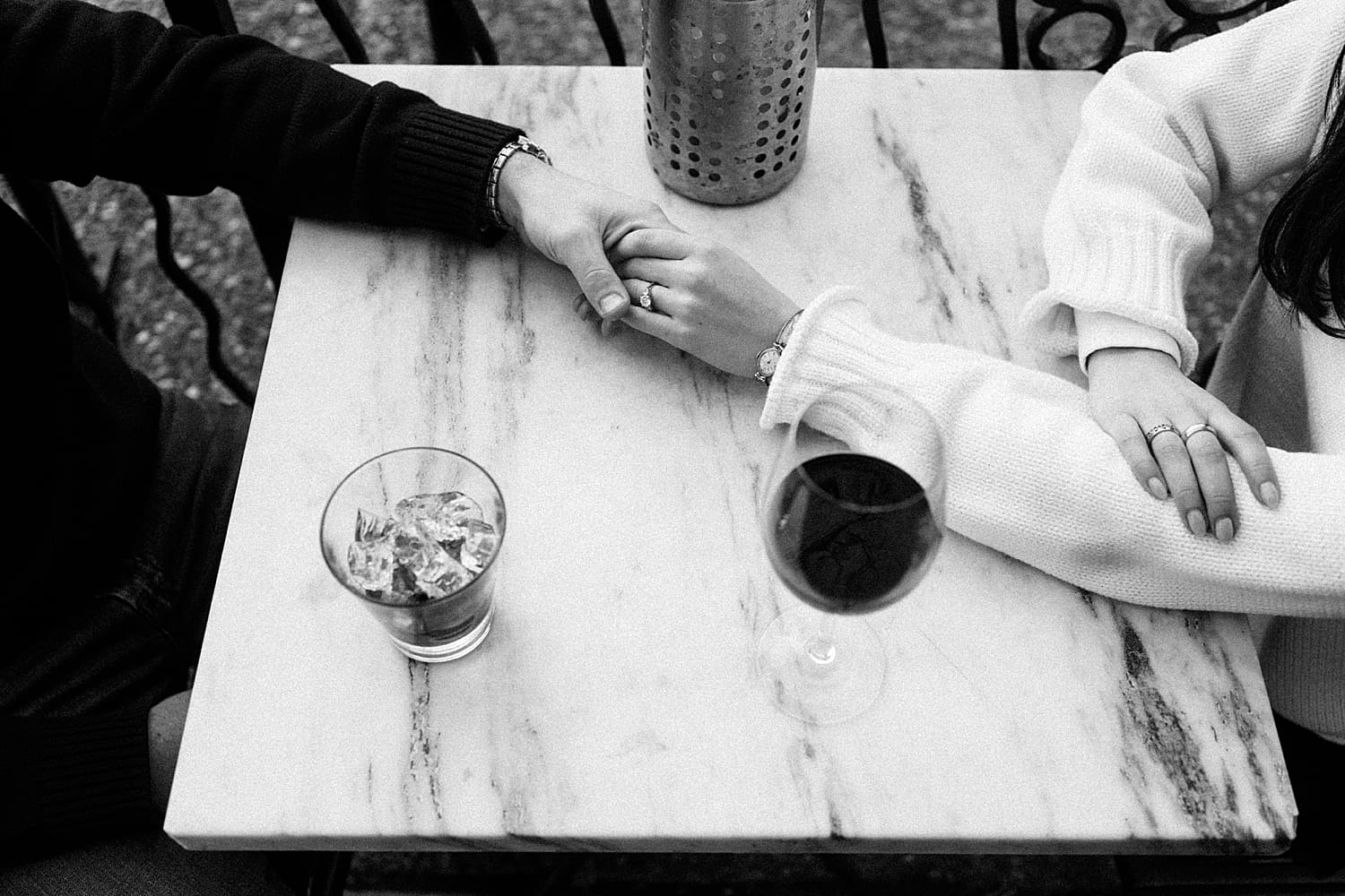 couple hold hands across table showing your engagement session should happen where you live