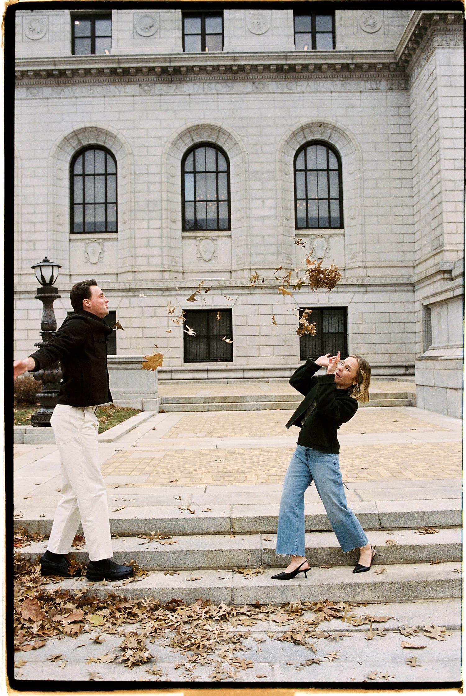 couple throw leaves in the air to celebrate by St. Louis wedding photographer