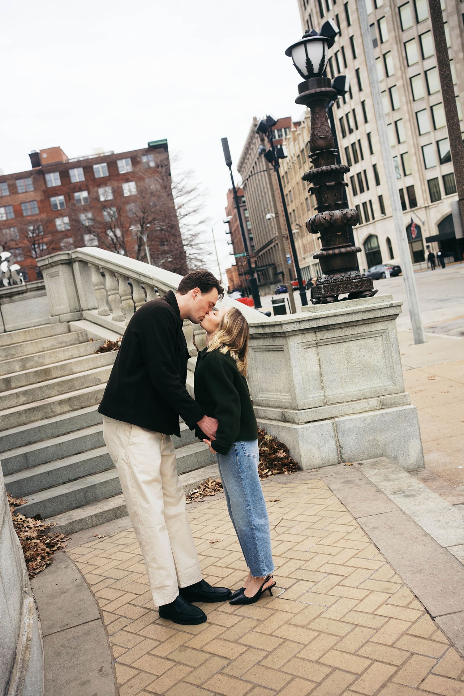 man leans down to kiss his fiance after learning how to feel natural in engagement photos