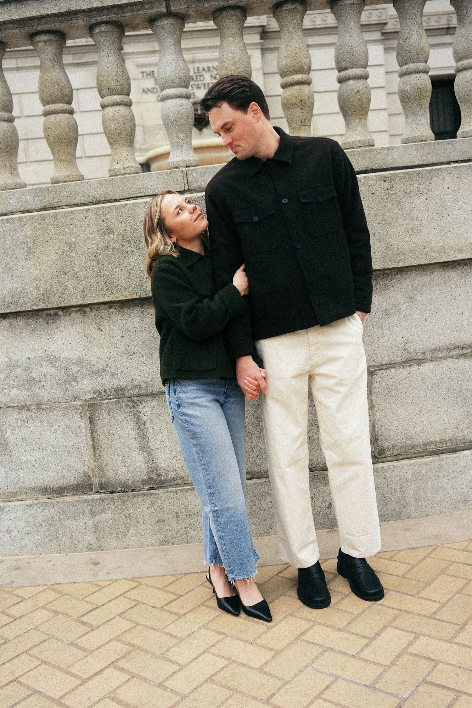 engaged couple snuggle on a sidewalk by St. Louis wedding photographer
