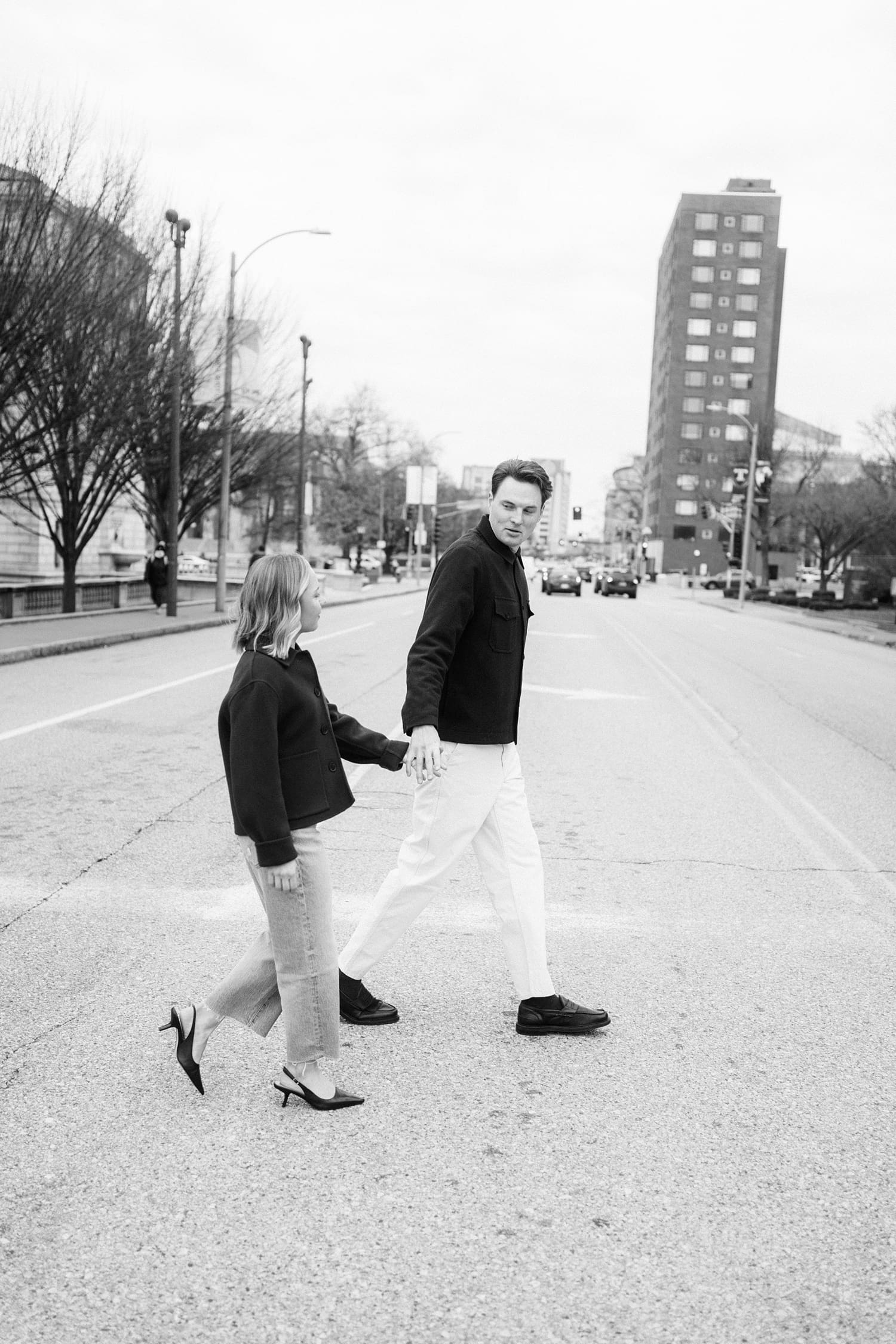 couple walk across the street hand in hand by St. Louis wedding photographer