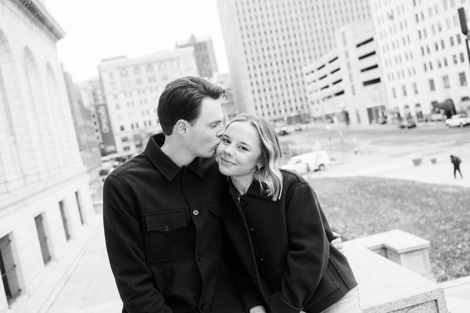 couple sit together in a busy city area by St. Louis wedding photographer