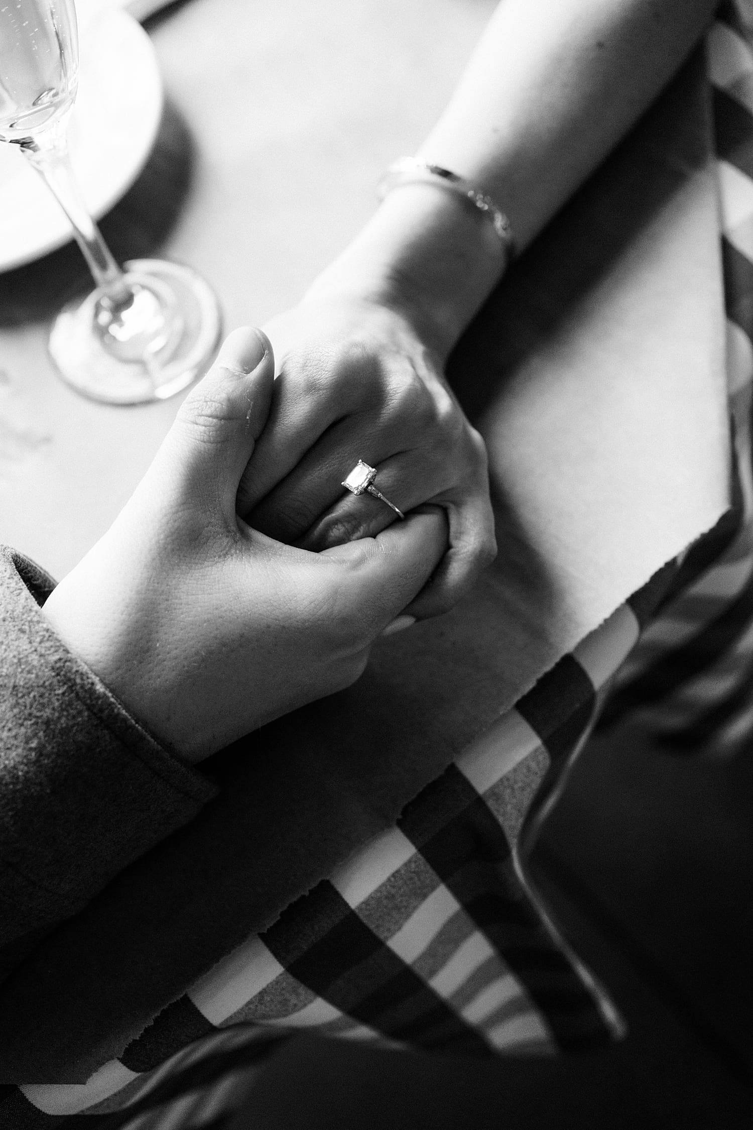 two people hold hand tightly over dinner table by St. Louis wedding photographer