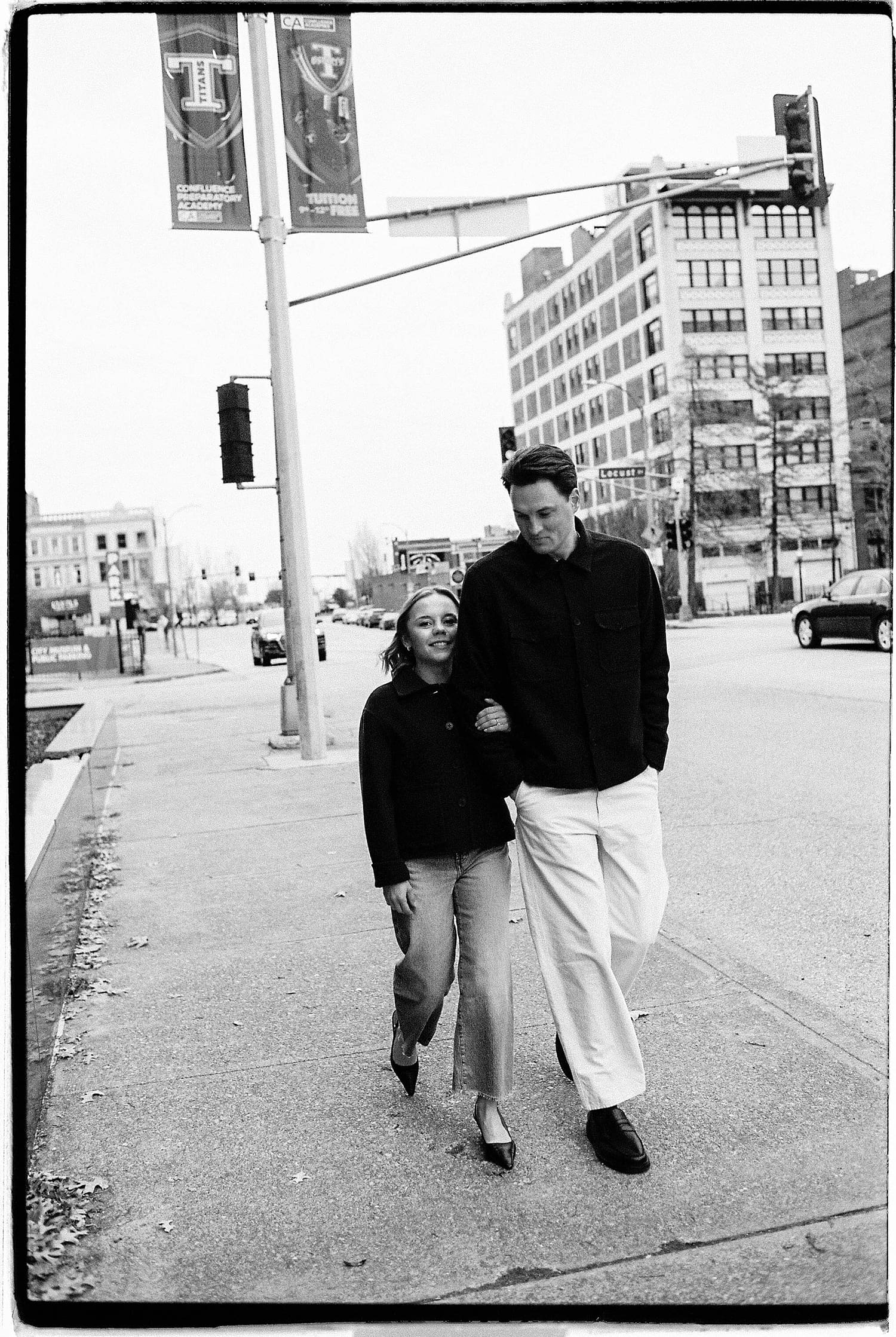 happy couple walks on sidewalk next to stoplight by Camille Meers Photography