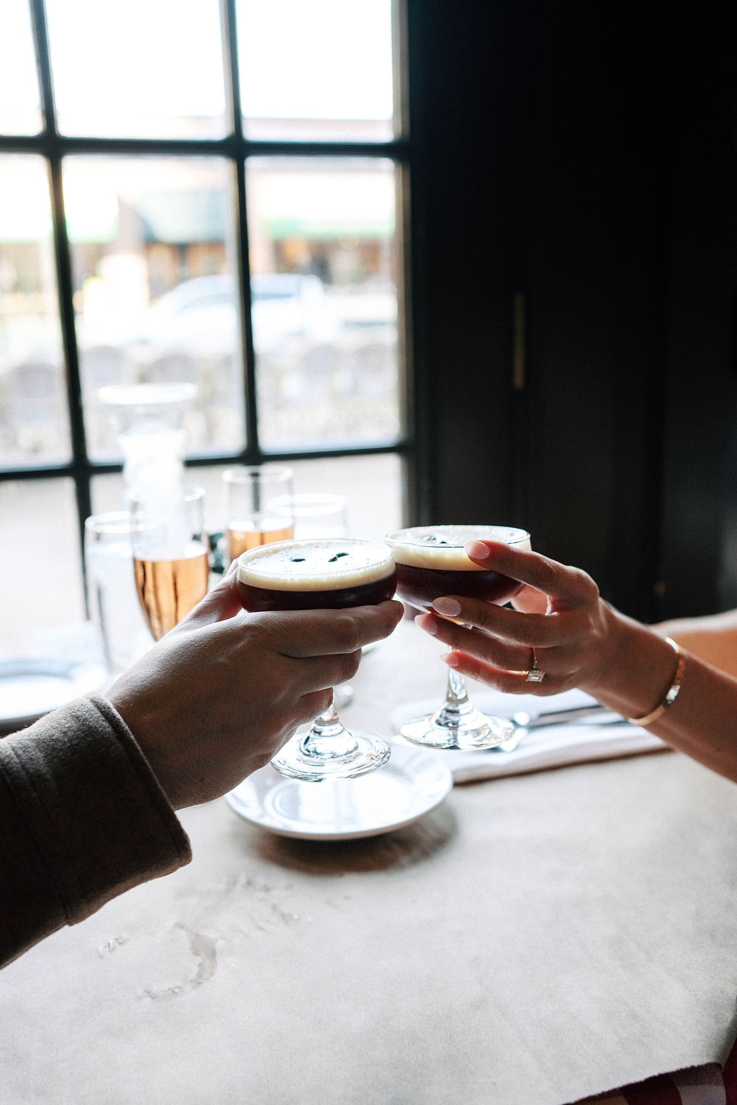 two people raise a toast with espresso martinis for photos that feel like date night
