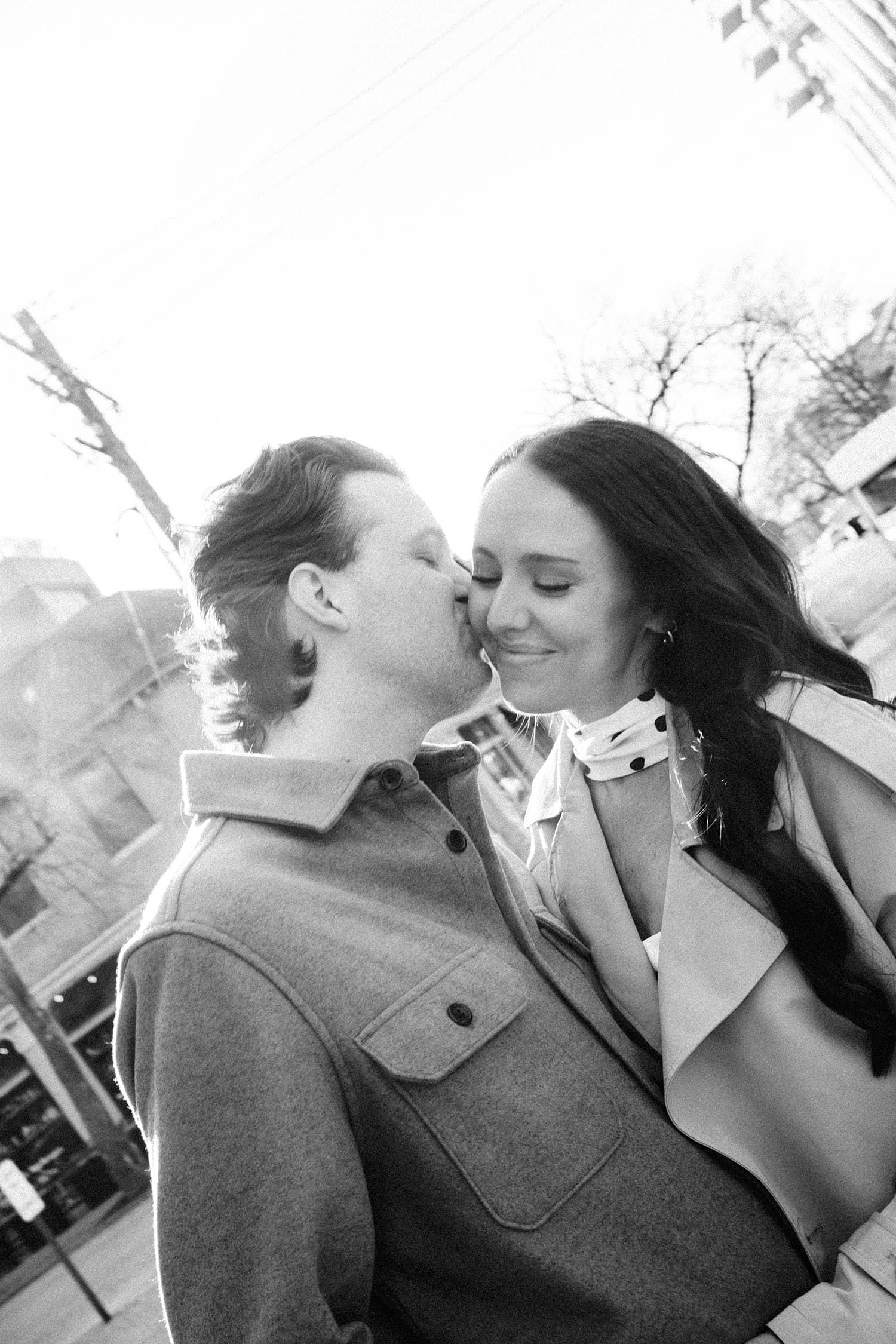 groom-to-be leans in to kiss woman's cheek by St. Louis wedding photographer