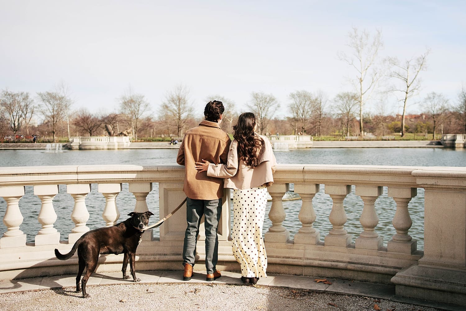 man and woman stand overlooking the water for photos that feel like date night