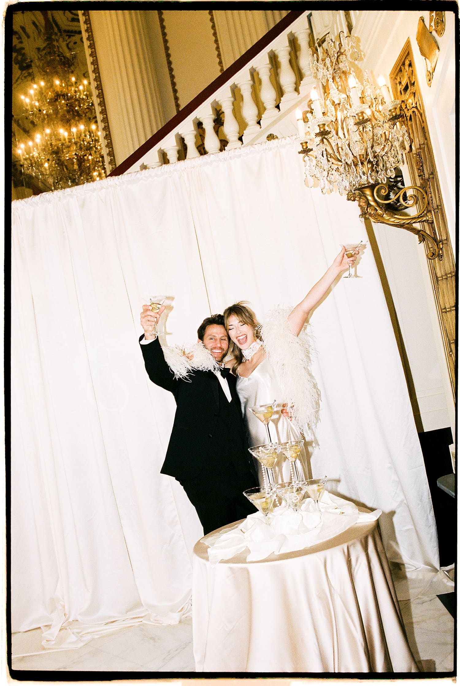 couple lifts drinks in celebration by Camille Meers Photography