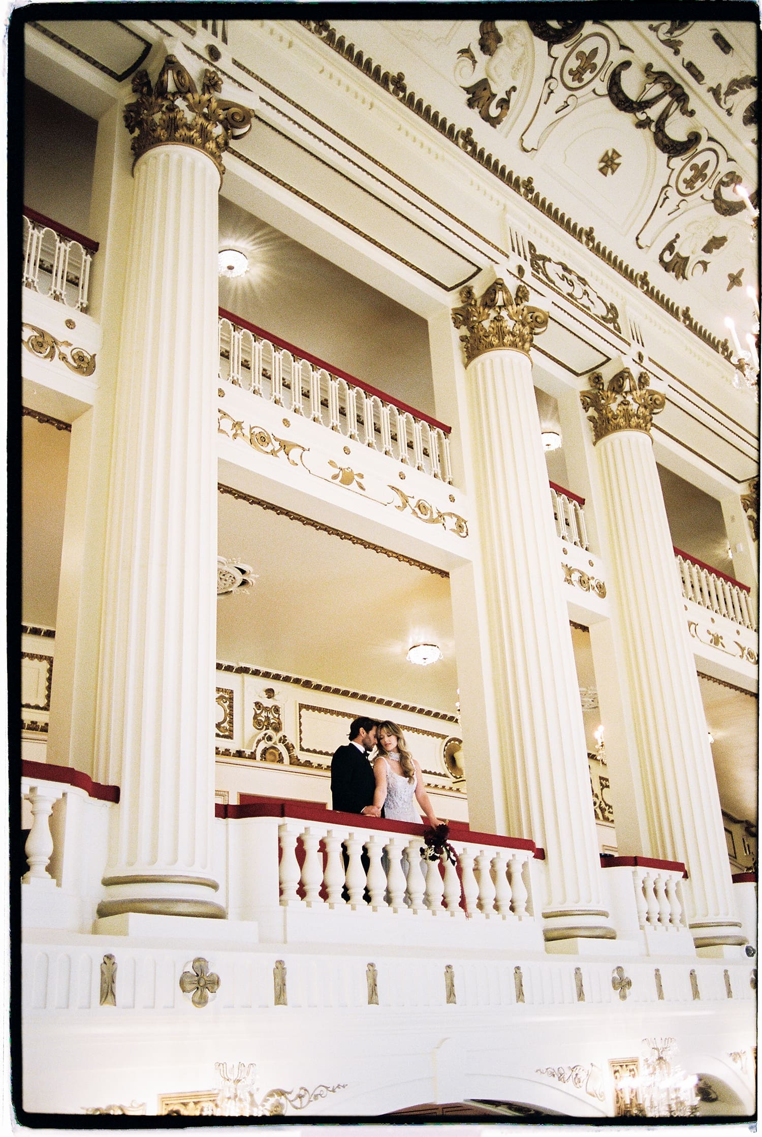 two people stand on balcony at theater by St. Louis wedding photographer