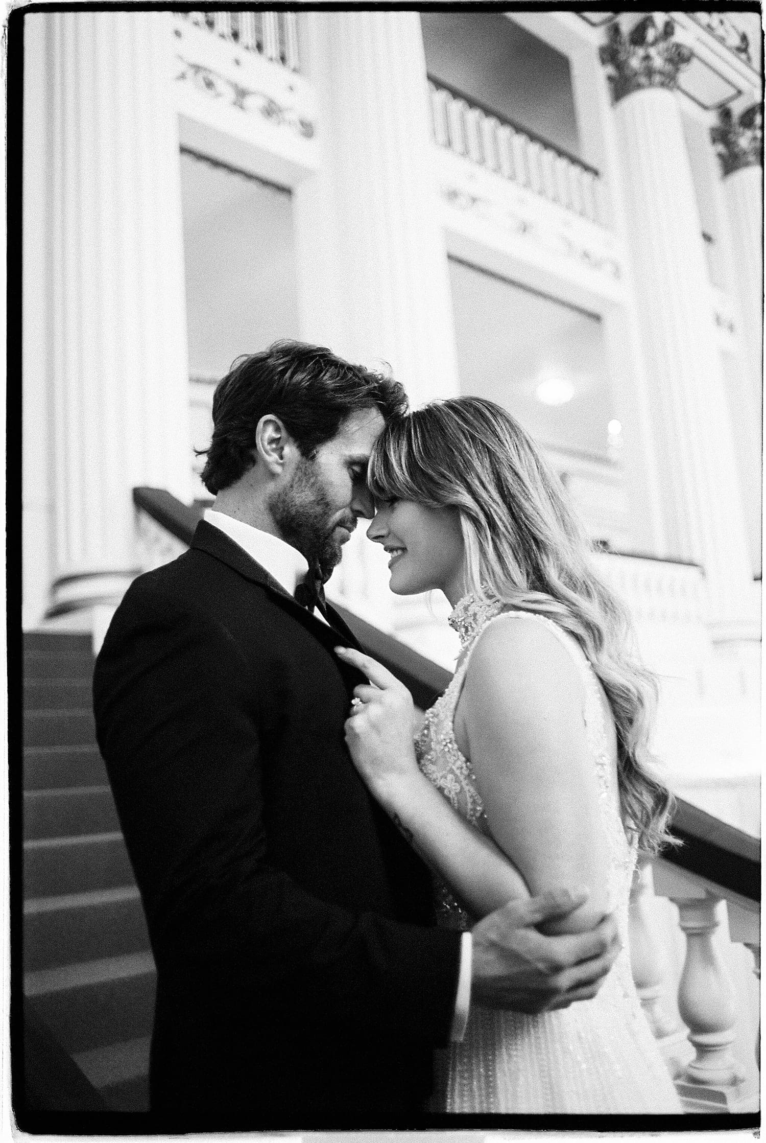 man holds his woman close on stairs by Camille Meers Photography