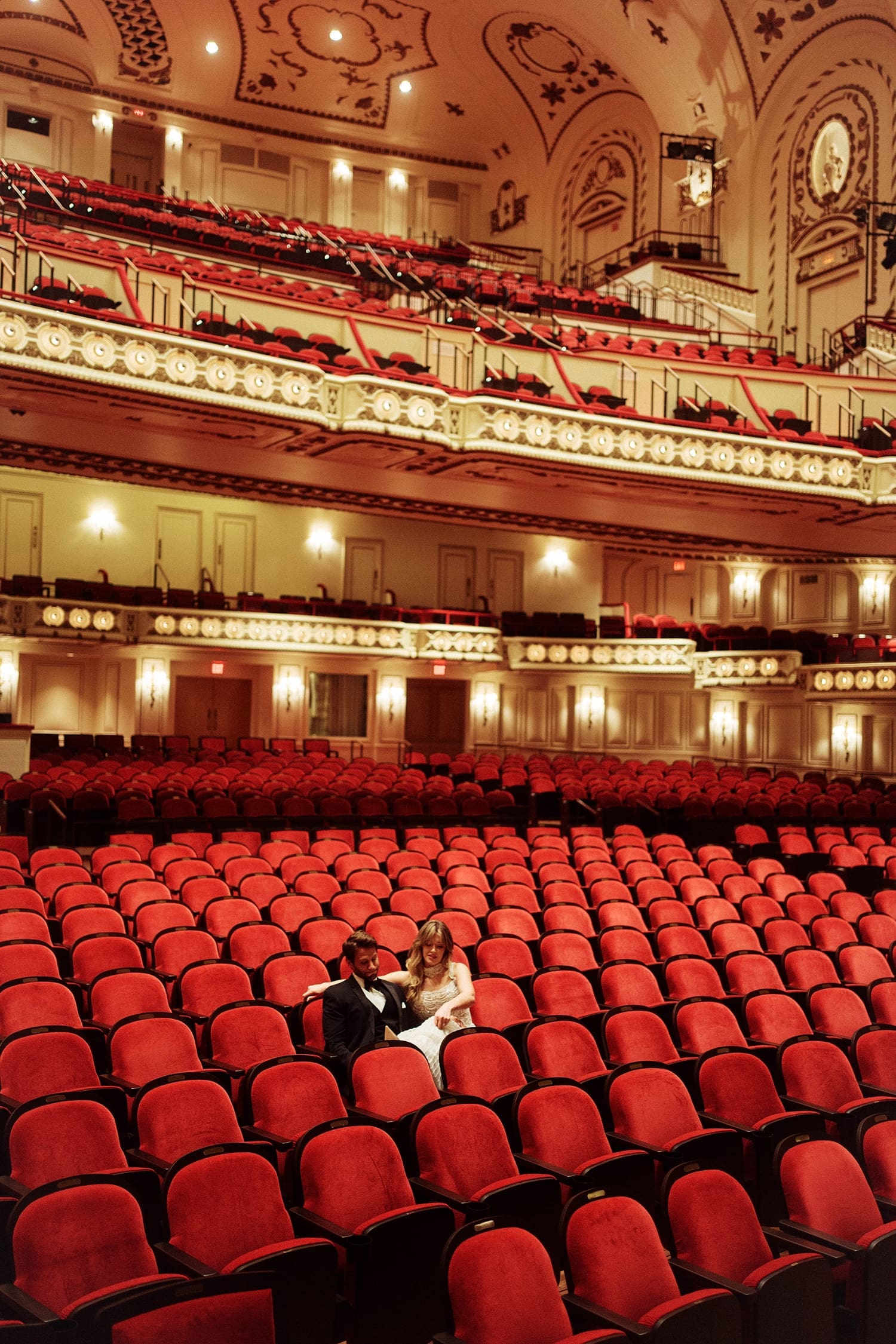couple sits in empty auditorium at Powell Hall