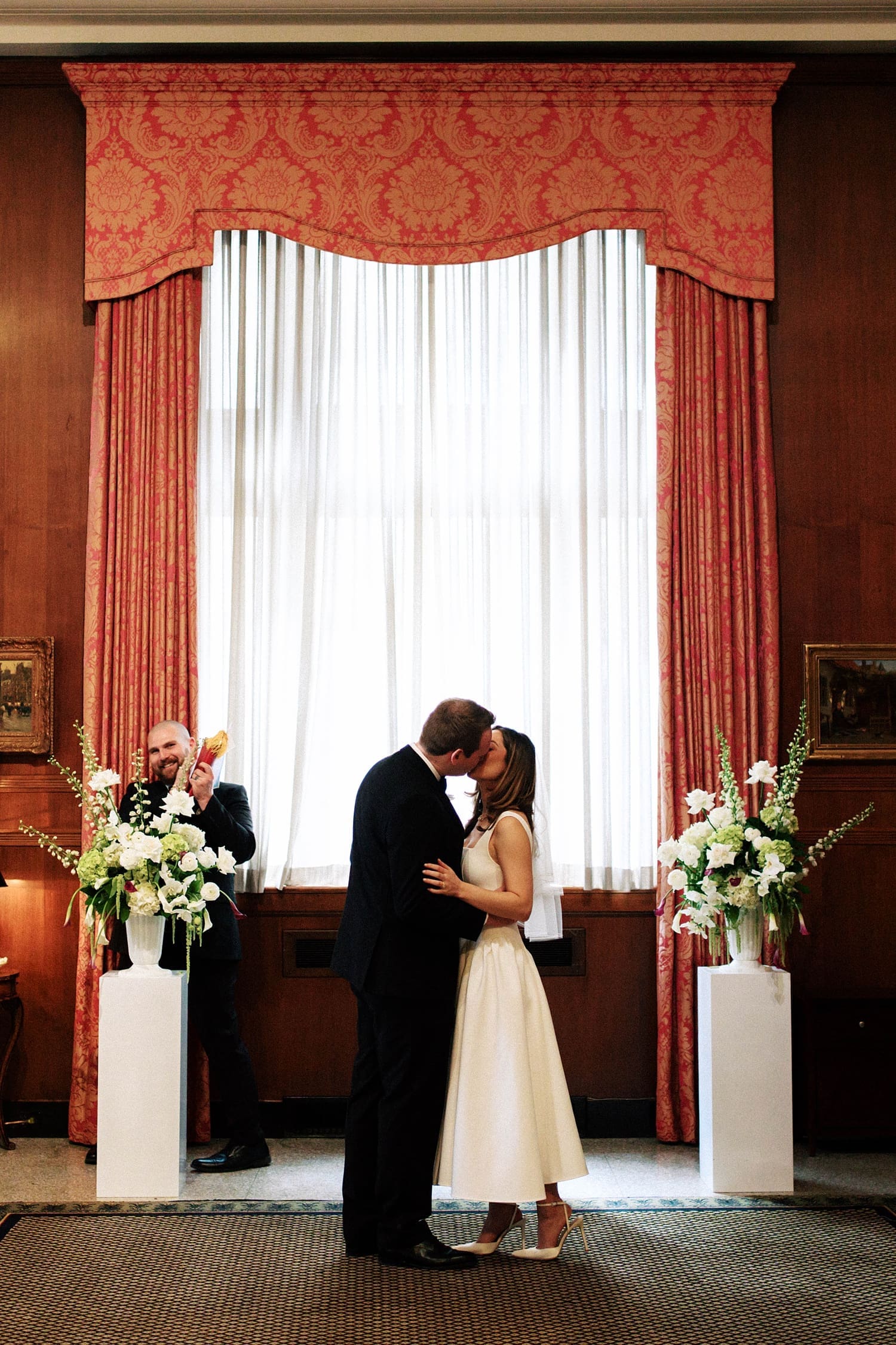 bride and groom share a kiss at their alter by Camille Meers Photography