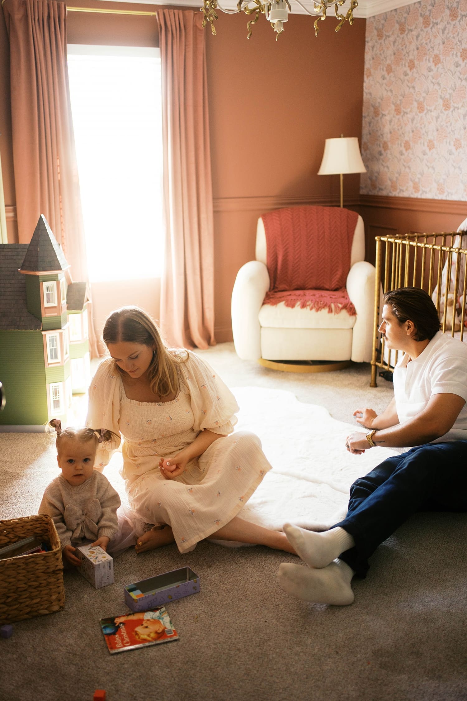 mom and dad play on the floor with their little one for relaxed family session at home