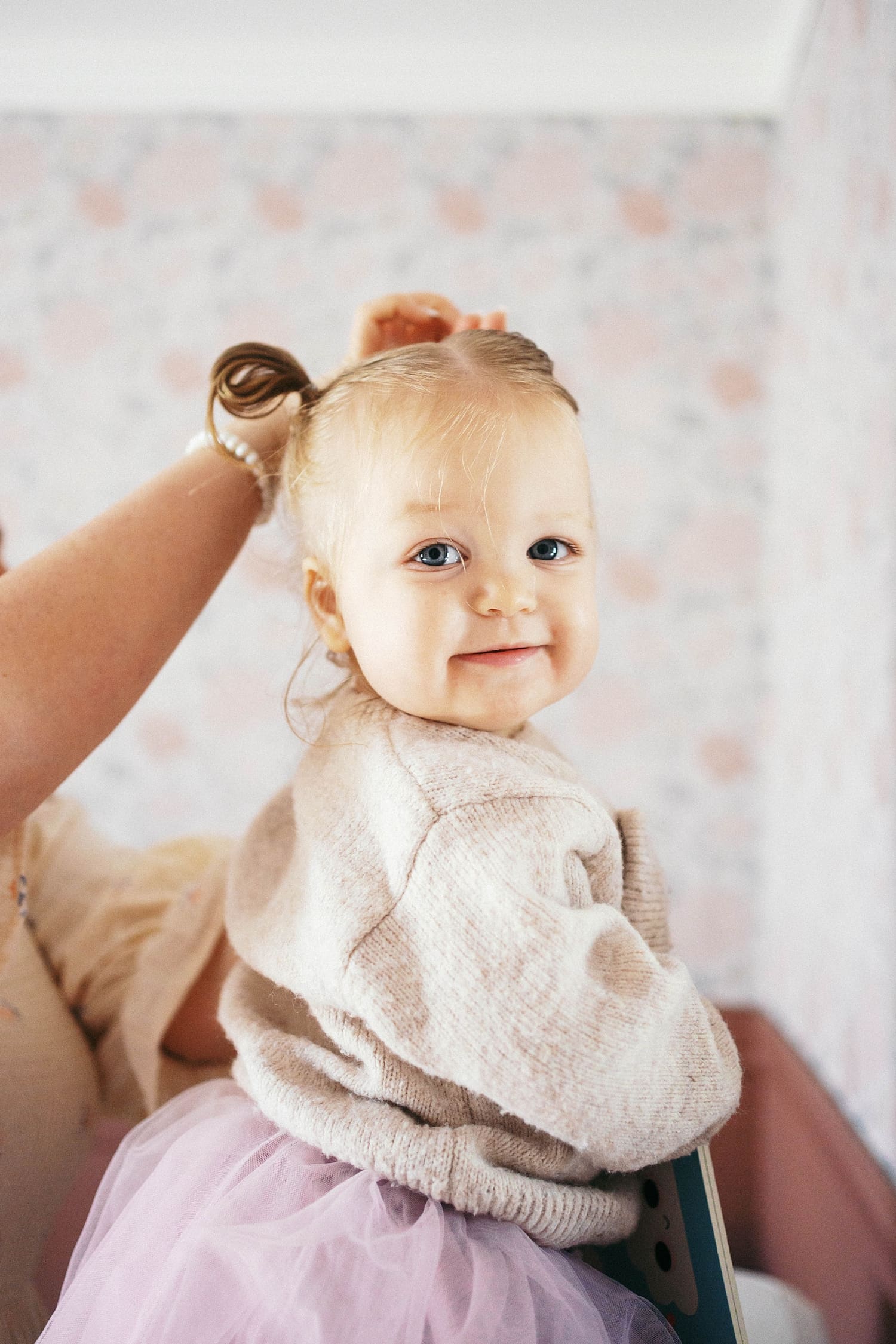 toddler gets her hair put up in pigtails by Camille Meers photography