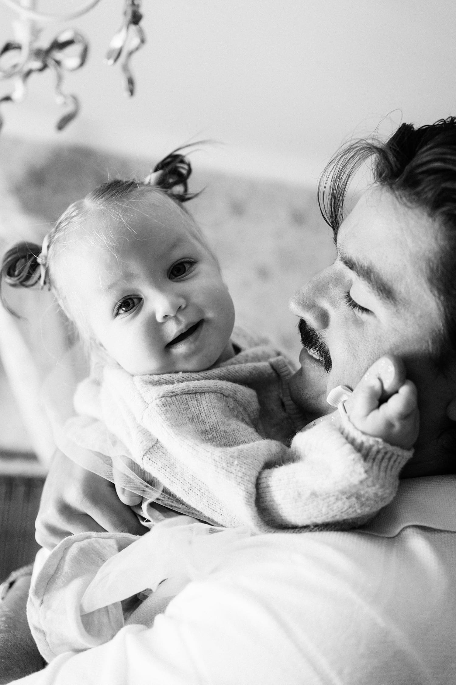 dad holds toddler on the couch for relaxed family session at home