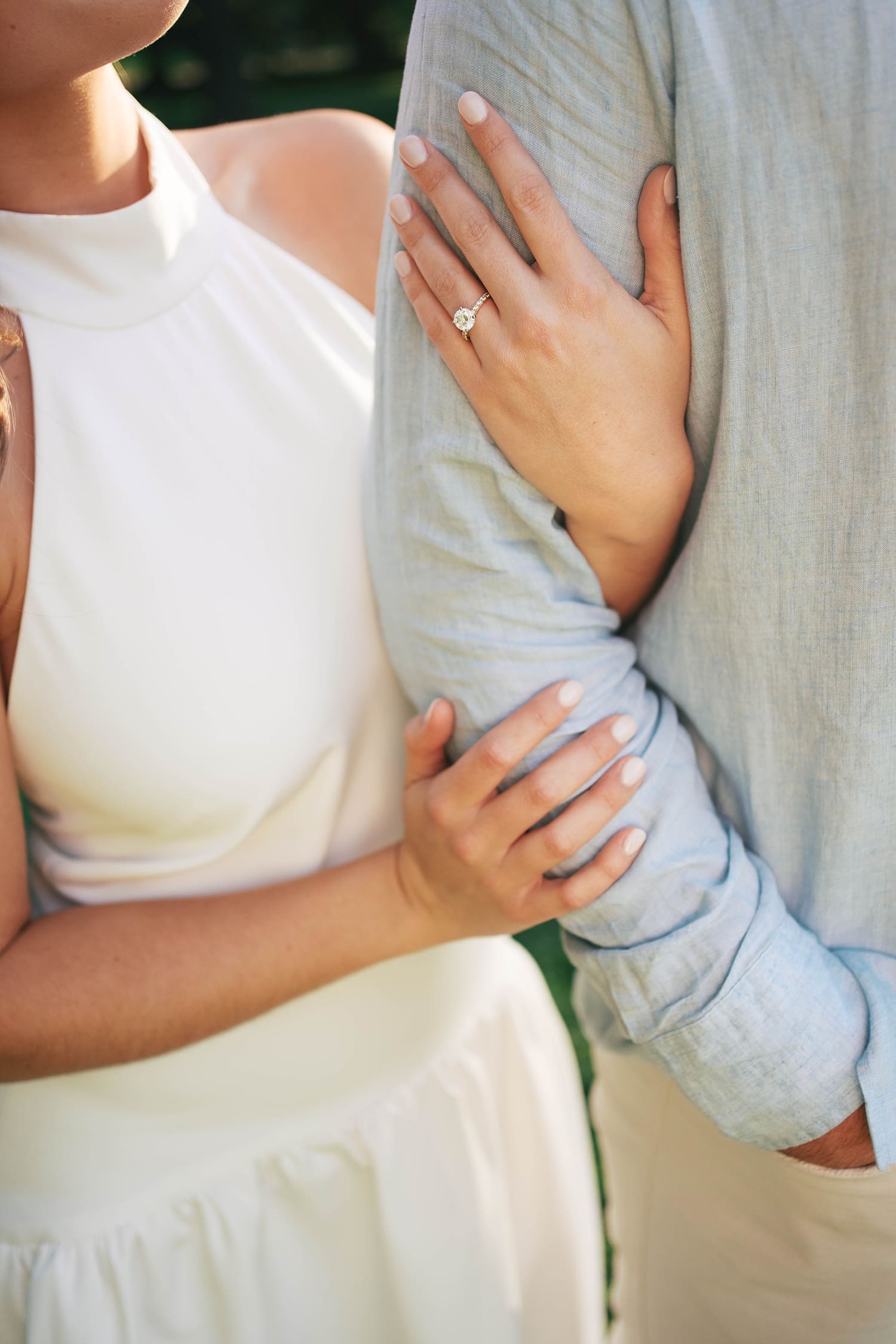 woman wraps her hand around man's arm, showing her diamonds ring by Camille Meers Photography