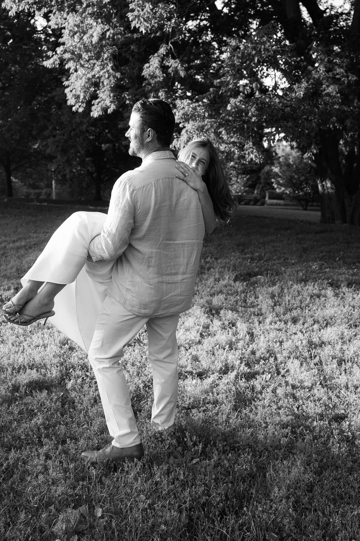 groom to be picks up woman and spins her for unposed engagement session