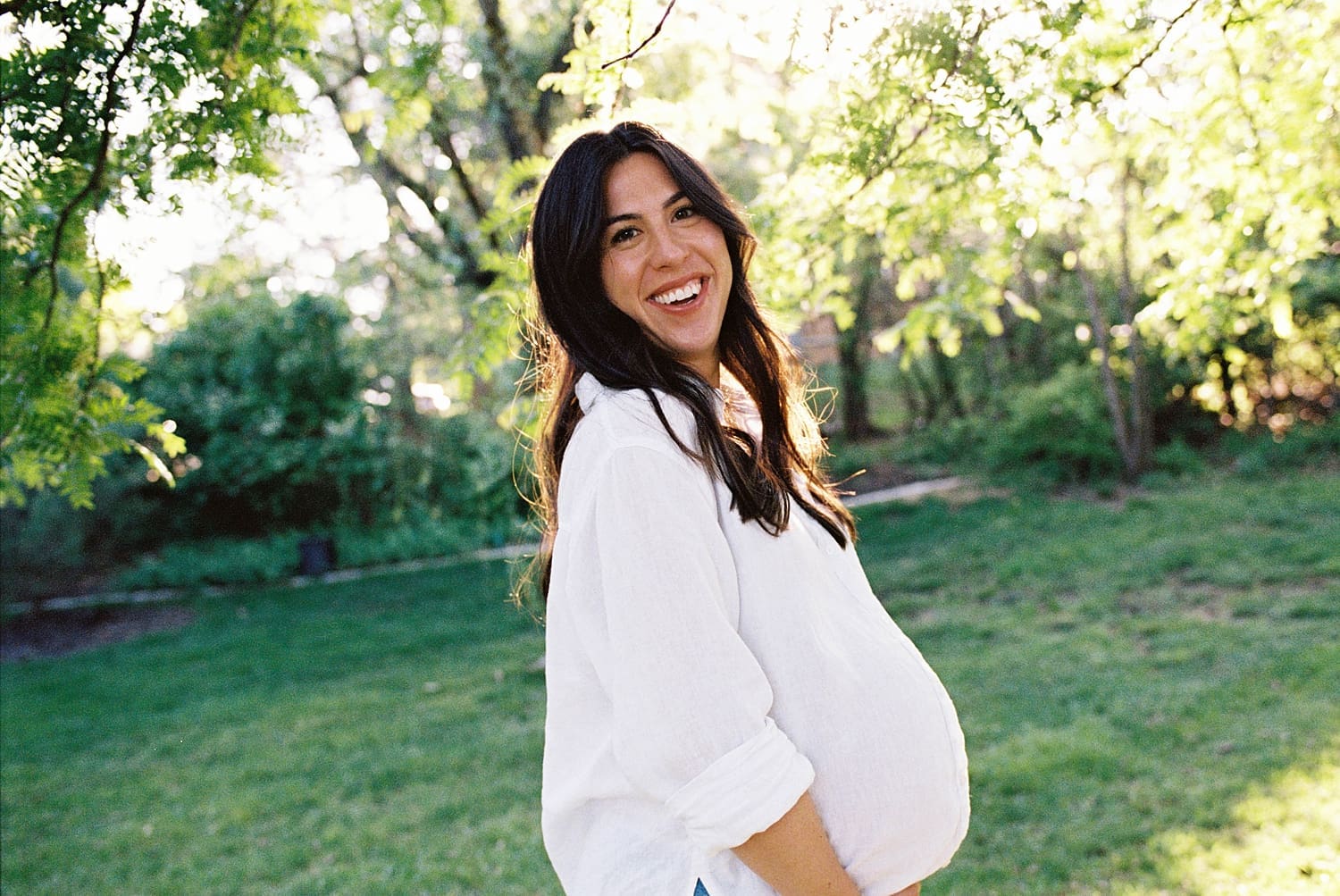 mom to be smiles in golden light by St. Louis family photographer