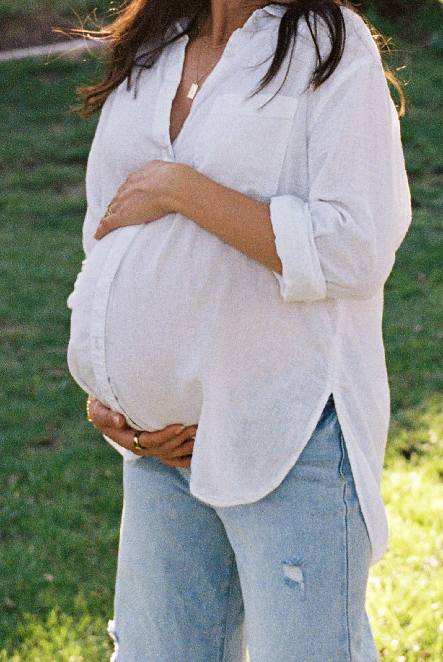 pregnant woman holds her belly by Camille Meers Photography