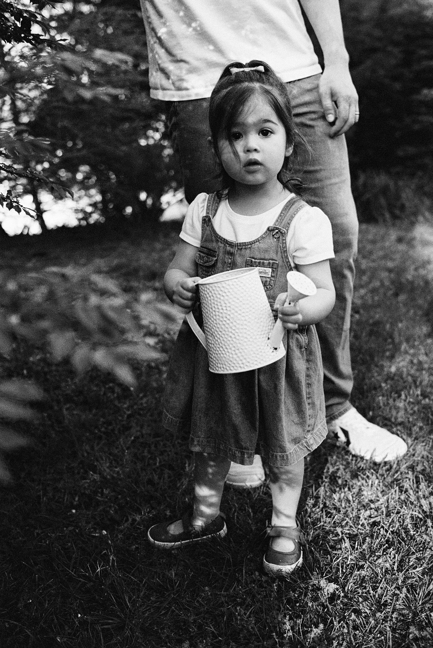 little girl hold watering can outside by St. Louis family photographer