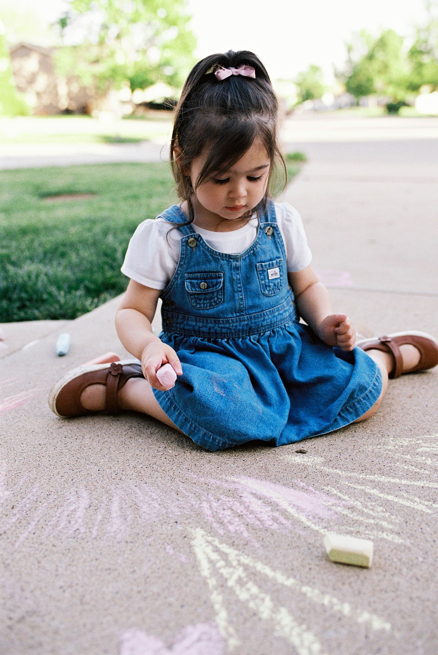 toddler coloring with chalk by mom for candid maternity photo session