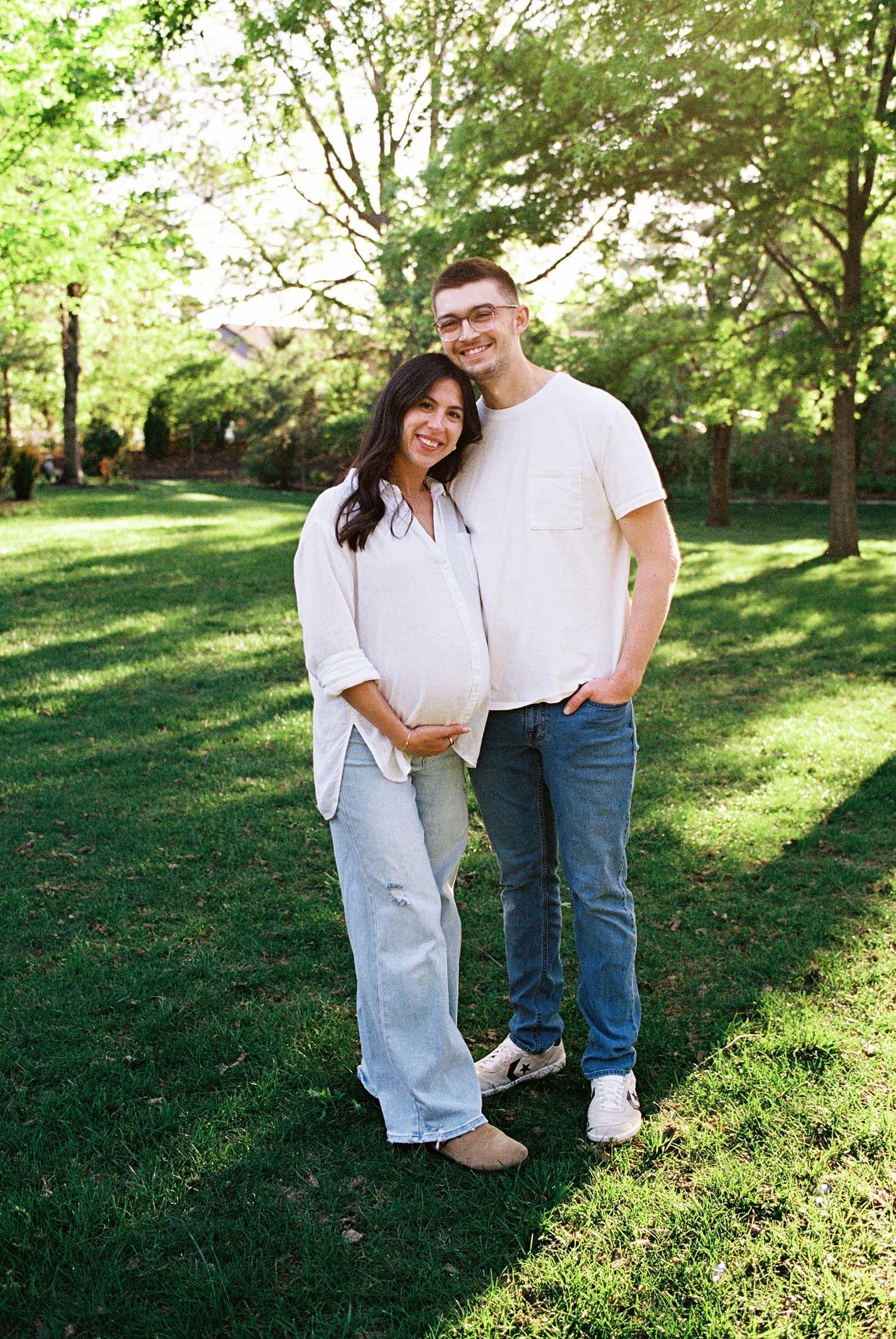 couple stand next to each other under big trees by Camille Meers Photography