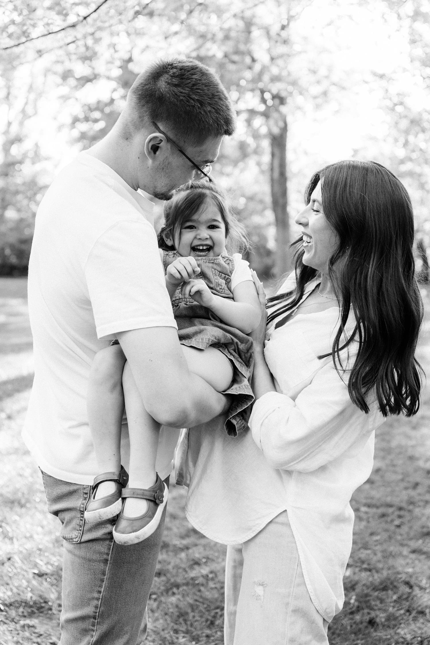 parents play with their toddler in backyard by St. Louis family photographer