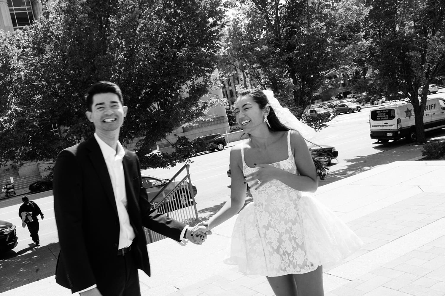 bride in little mini dress giggles on the sidewalk by Missouri elopement photographer